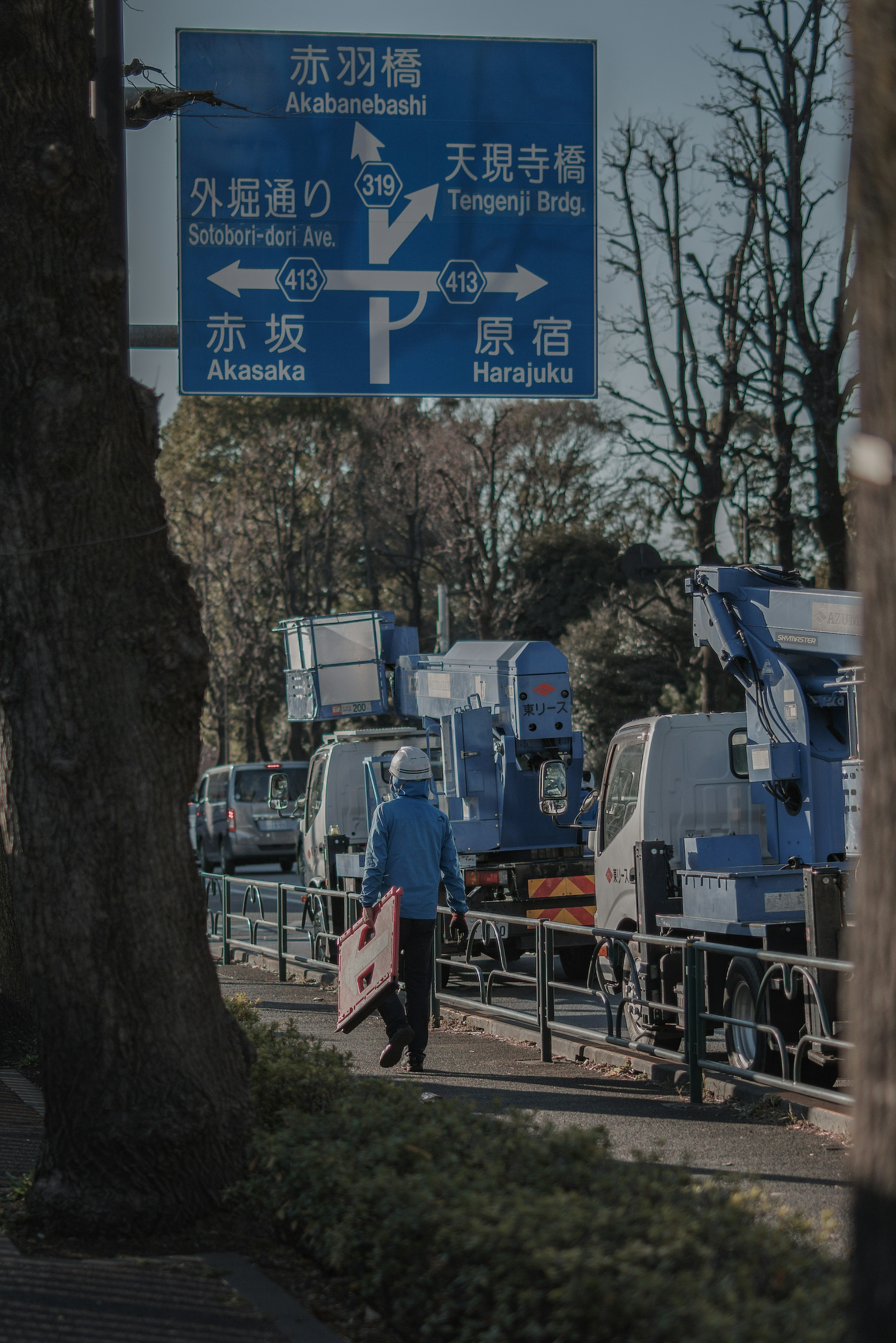 Scena con segnale blu e camion in fila