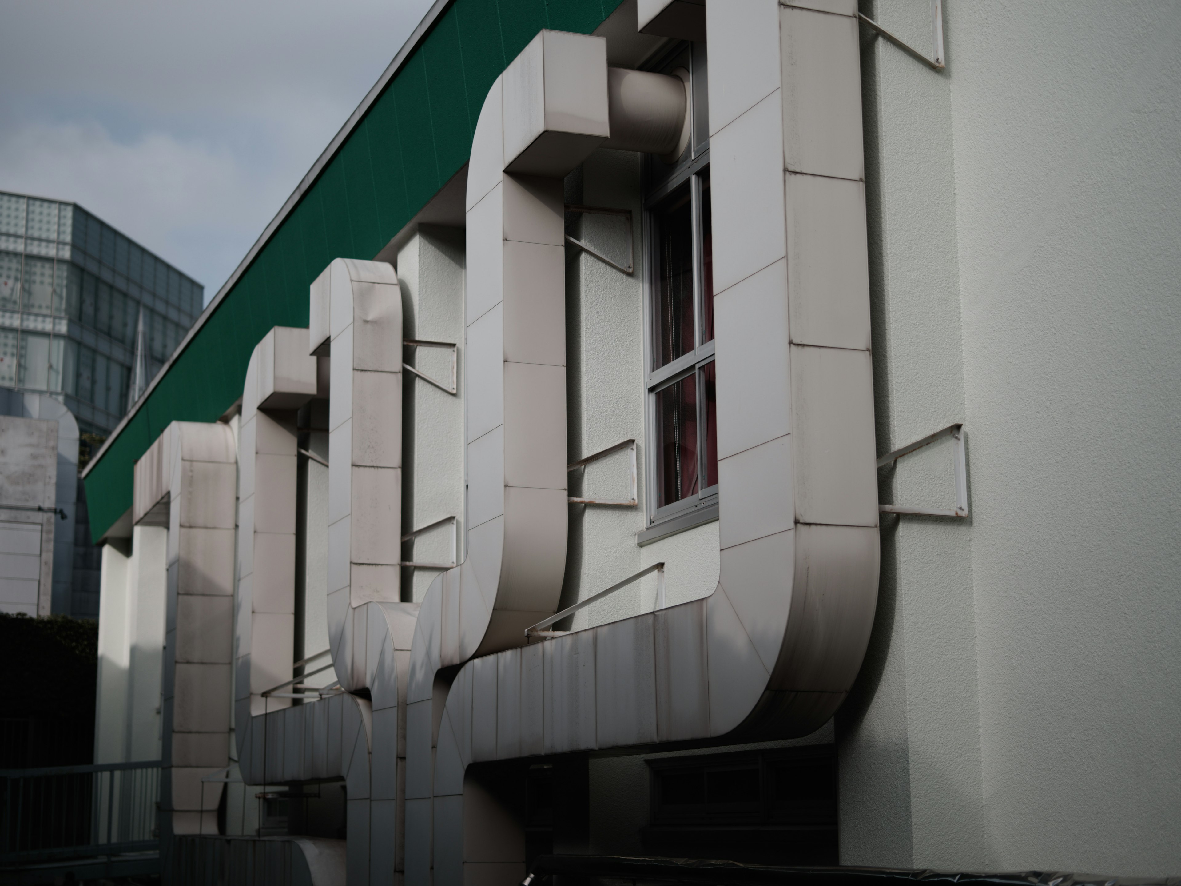 Distinctive building facade featuring metal ducts and windows