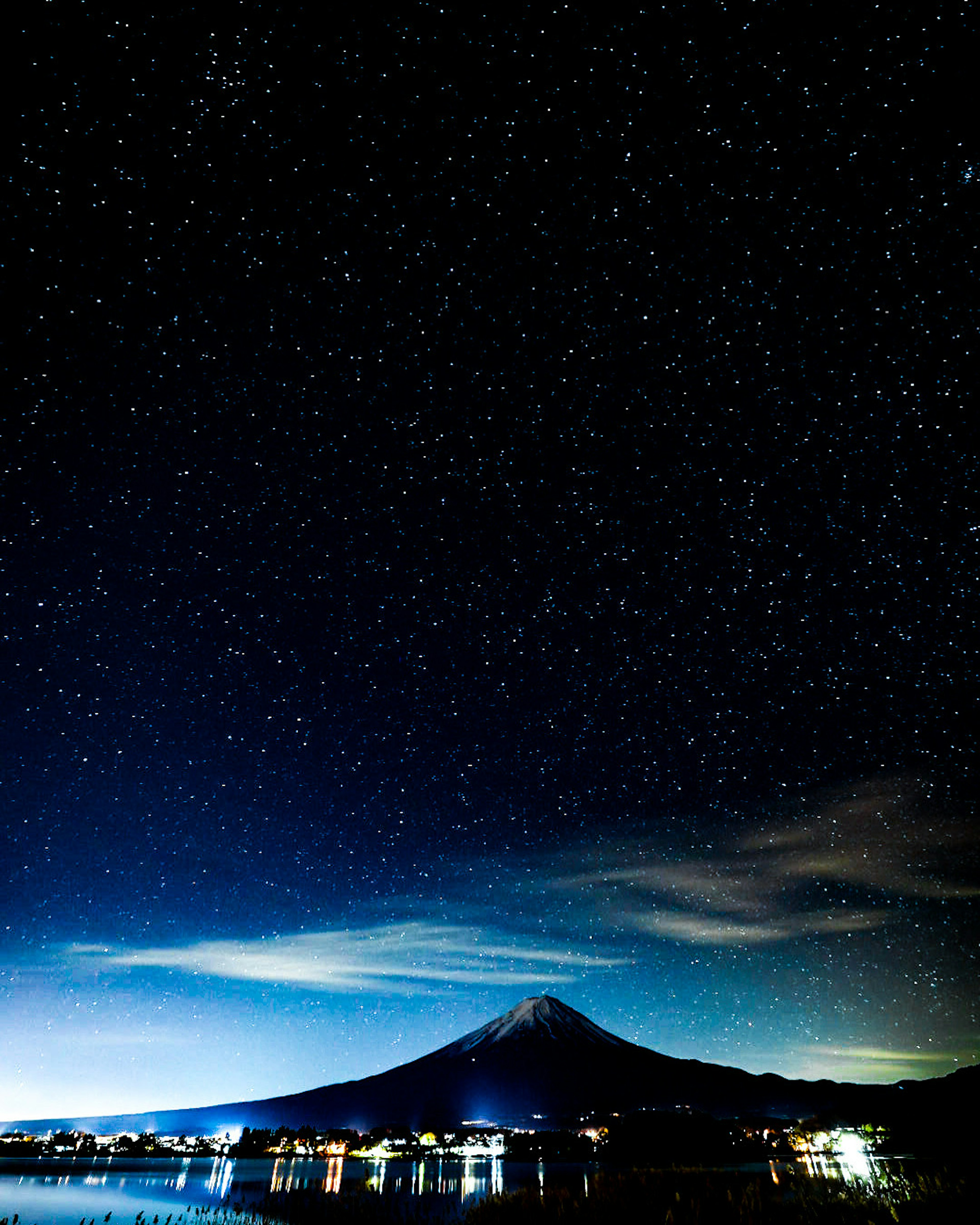 星空の下にそびえる富士山の美しい夜景