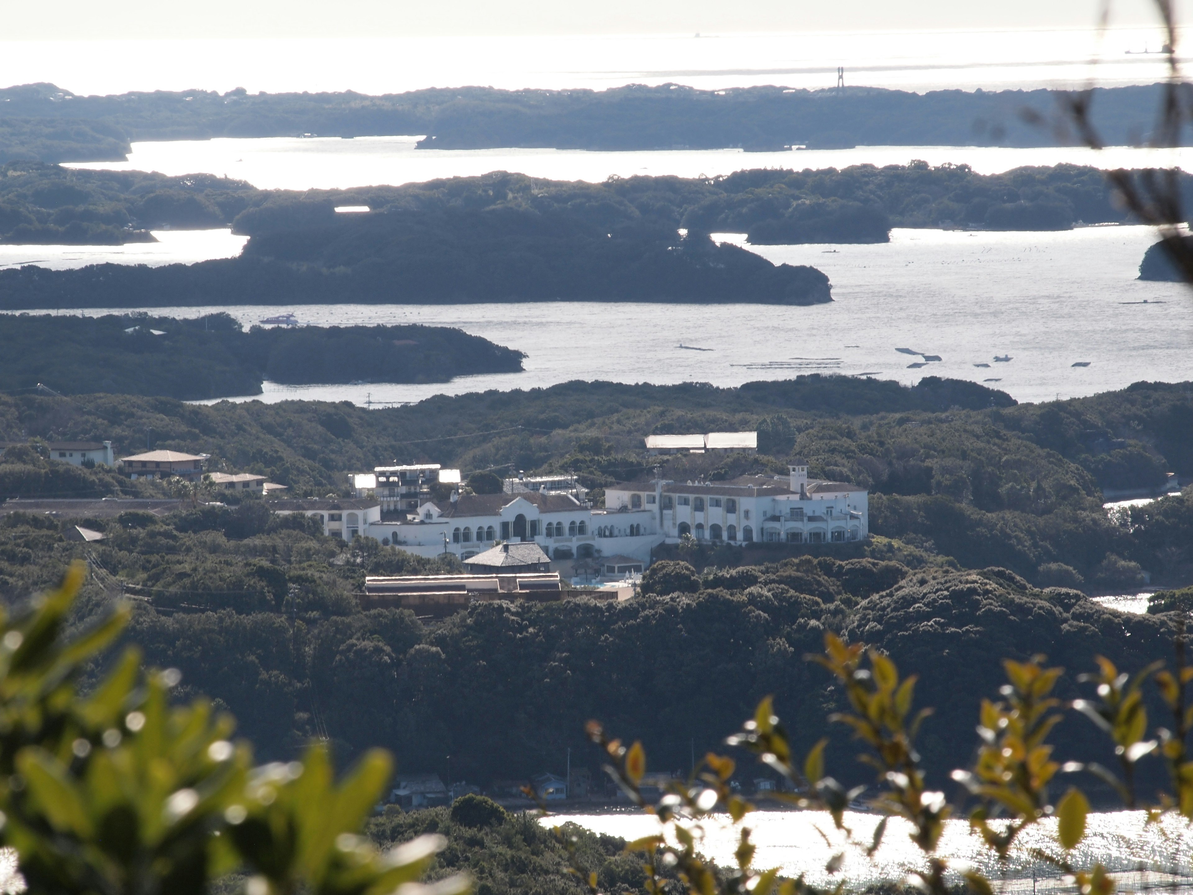 Vue éloignée d'un bâtiment blanc entouré d'îles vertes et d'eau