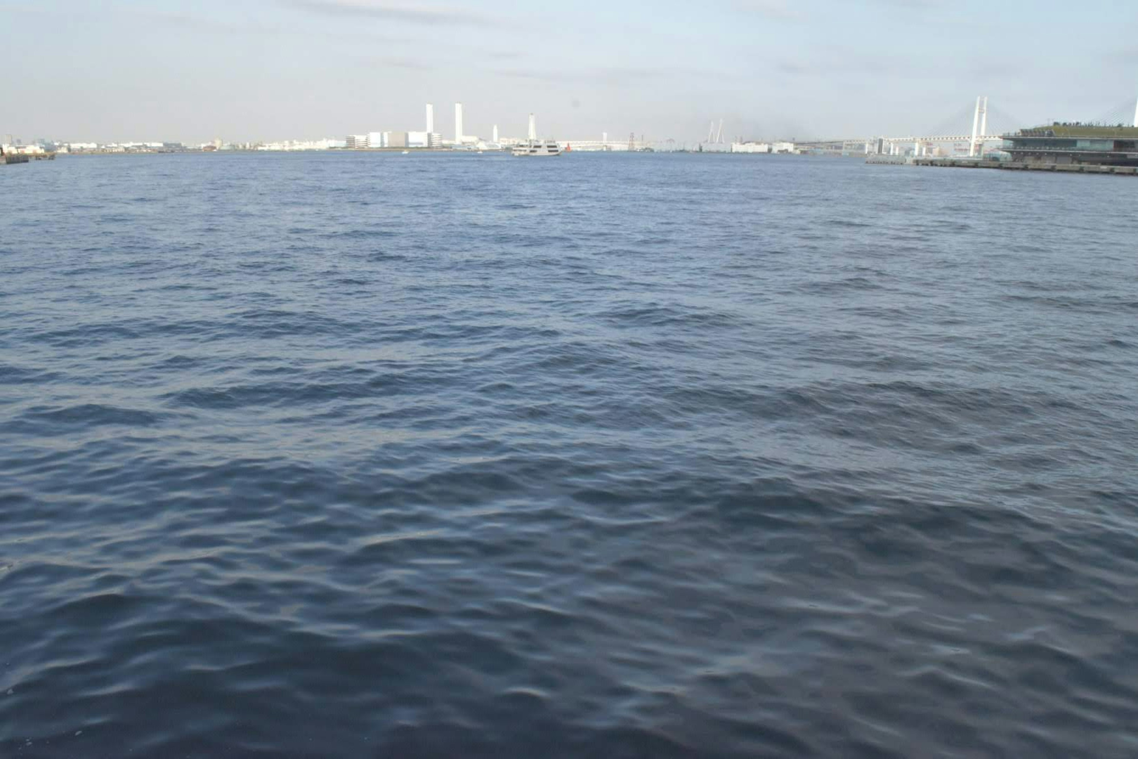 Calm sea surface with a city skyline in the background