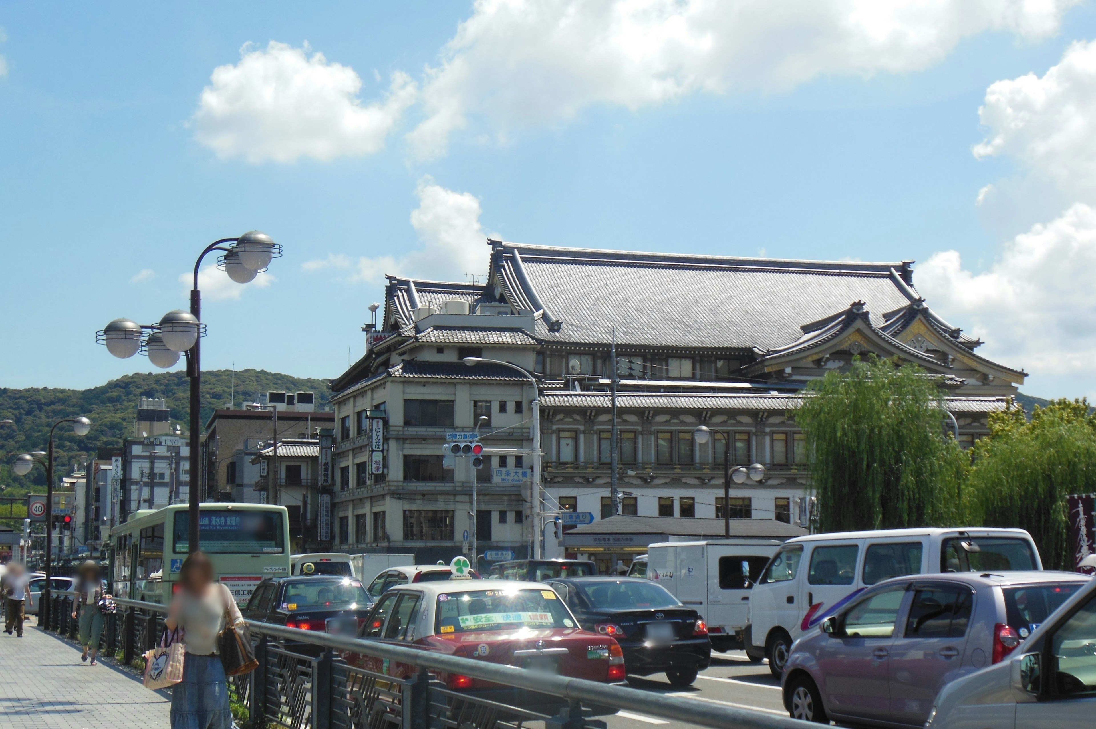 交通の多い通り沿いにある伝統的な建物と現代的な車両が見える風景