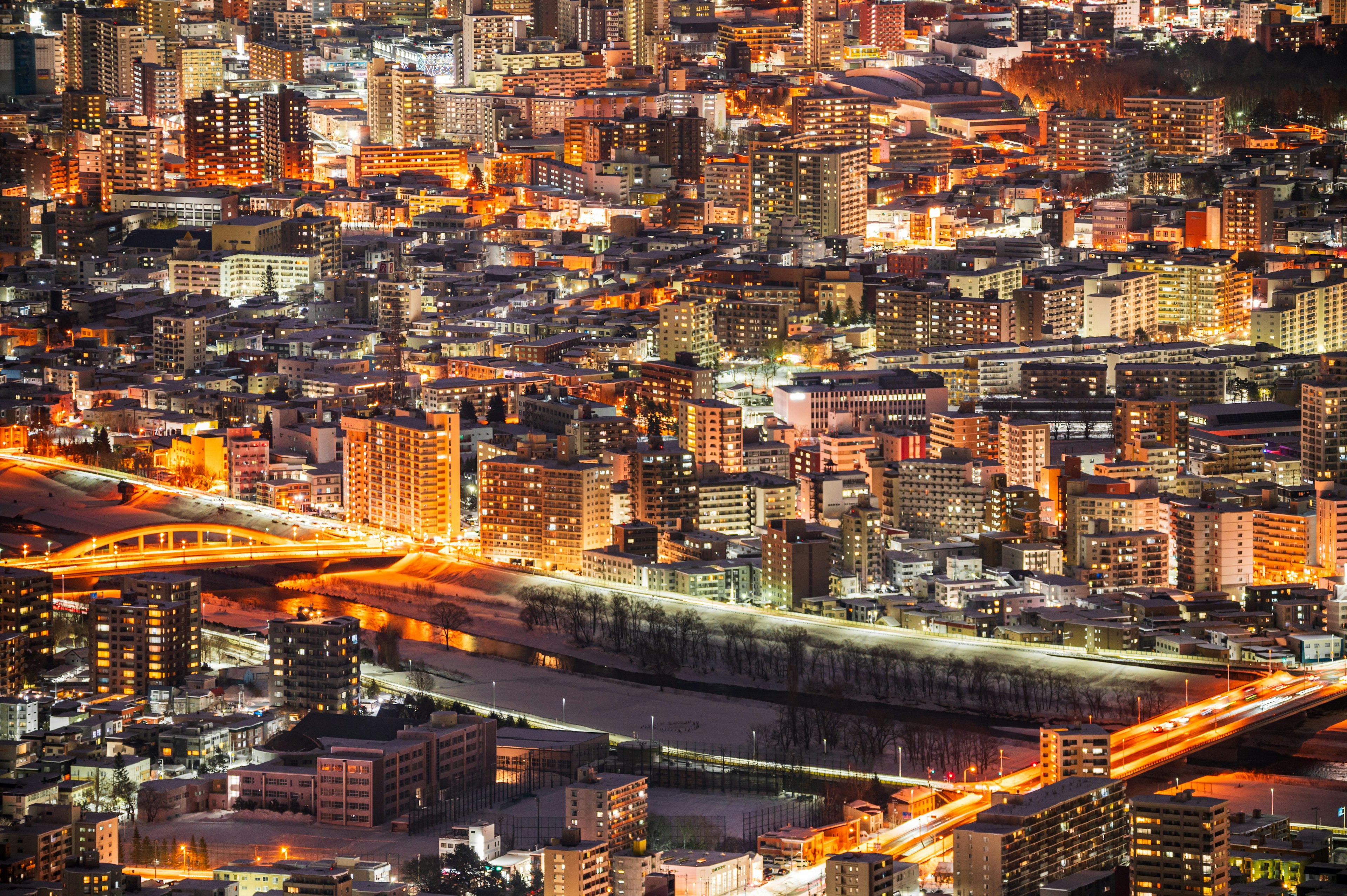 夜景の都市風景 光るビルと川の上の橋