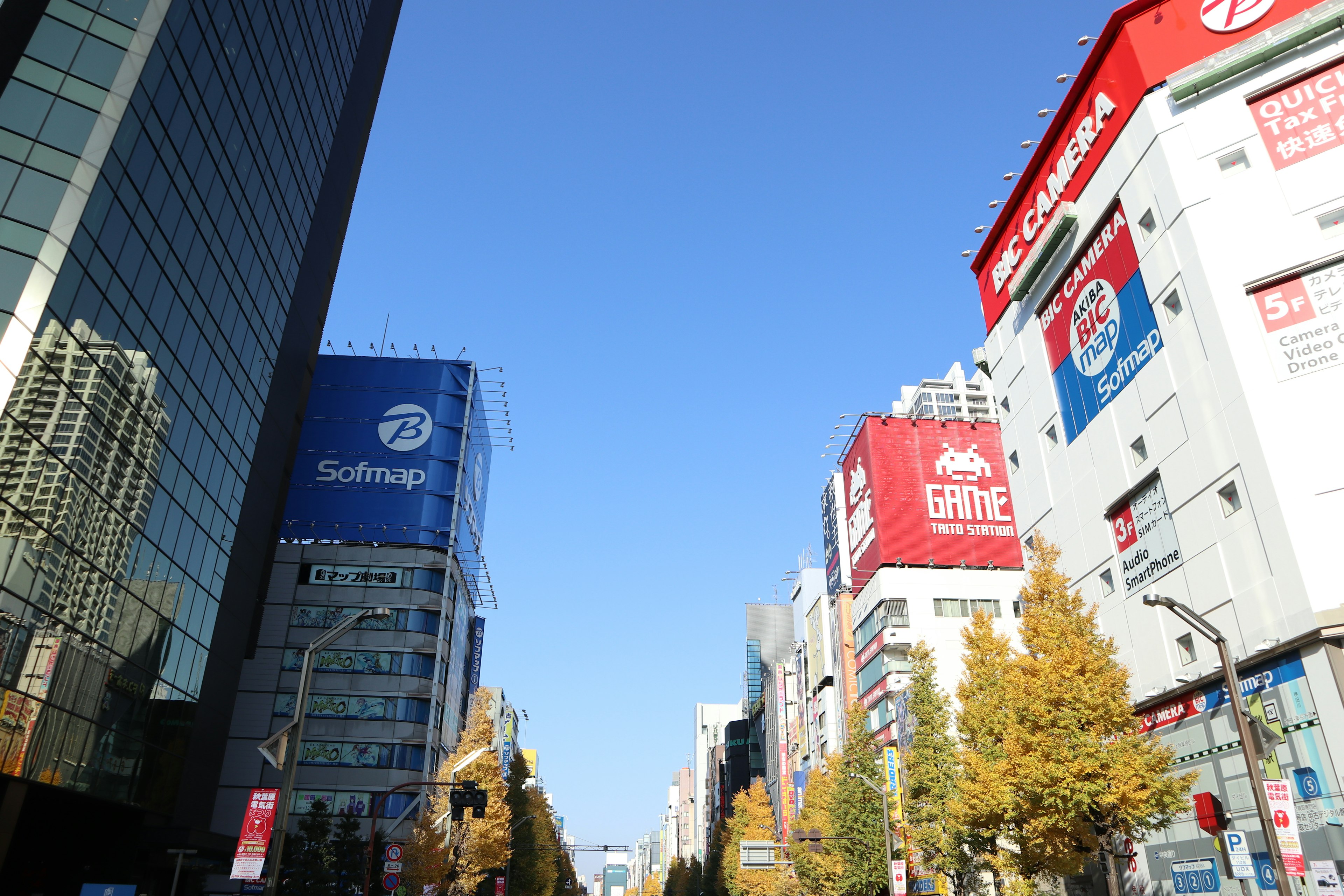 青空の下にあるビルと広告が並ぶ街並み