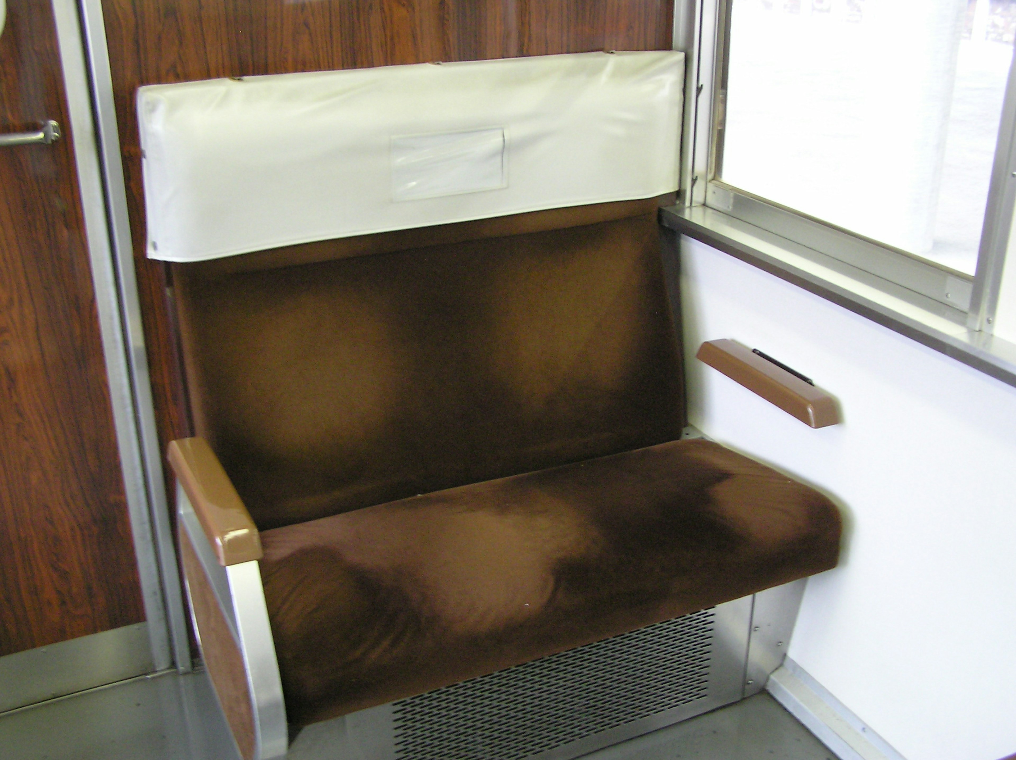 Worn brown fabric seat in an old train compartment