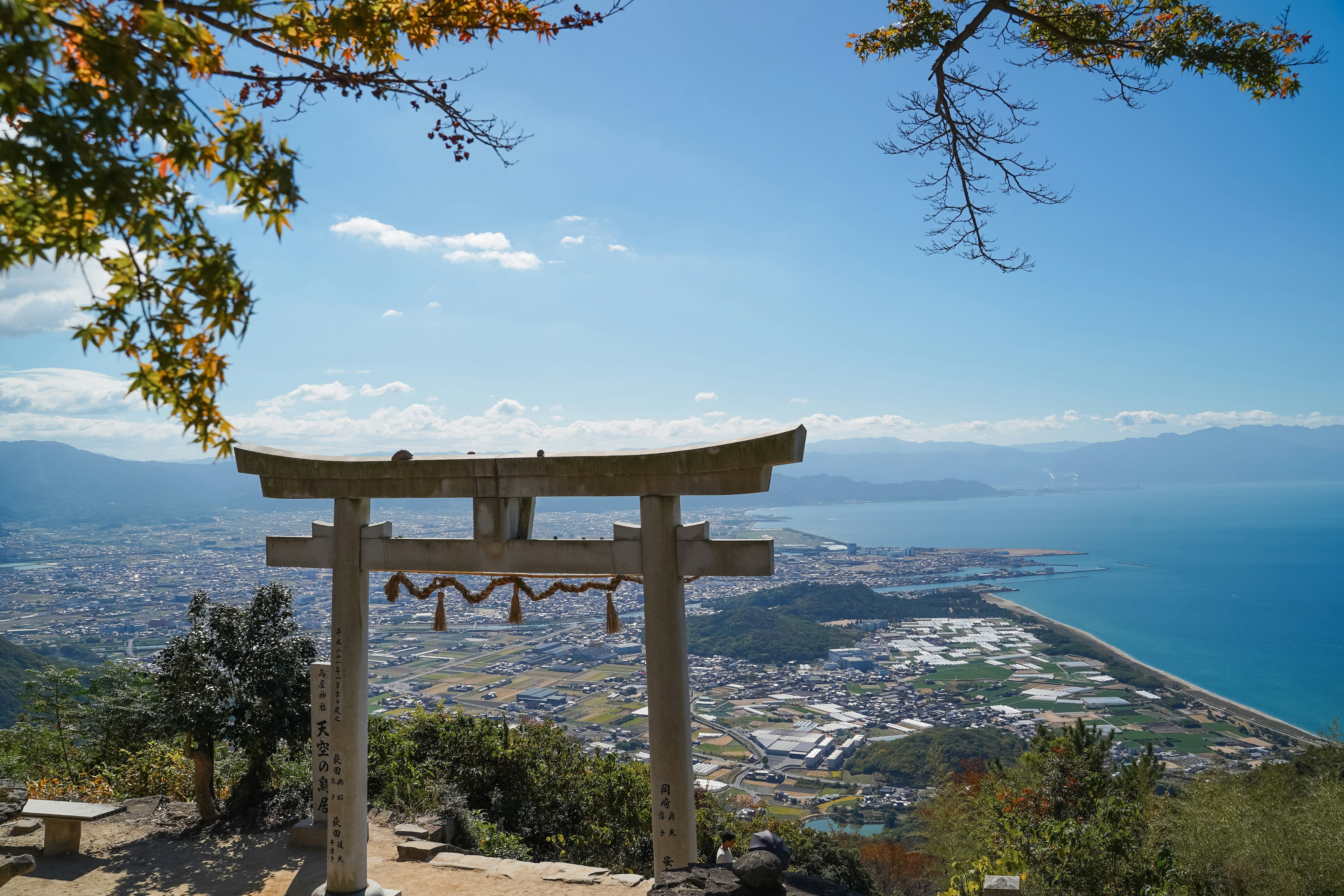 Gerbang torii dengan pemandangan laut di bawah langit biru