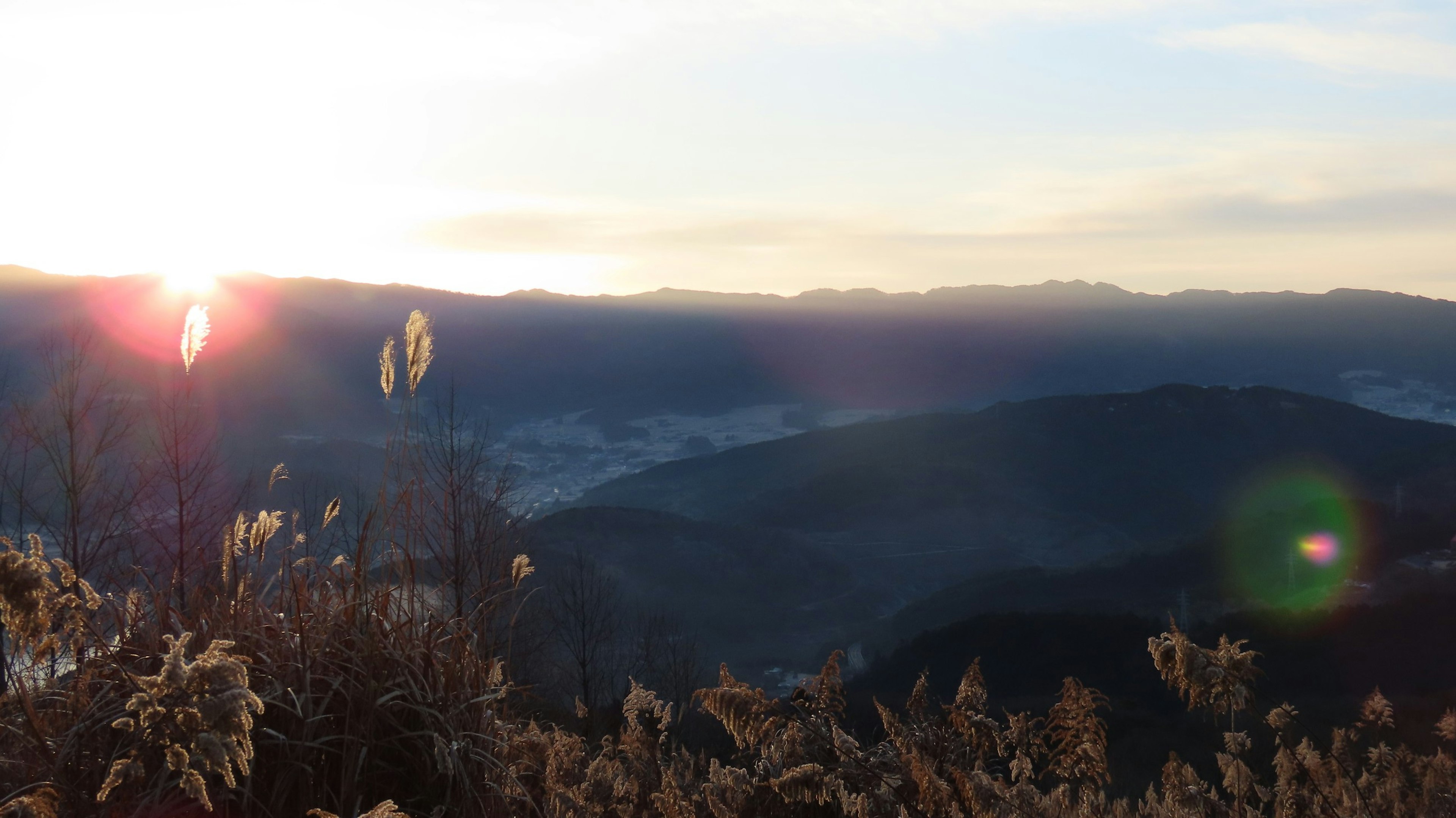 Scenic view of mountains and grasslands with sunrise