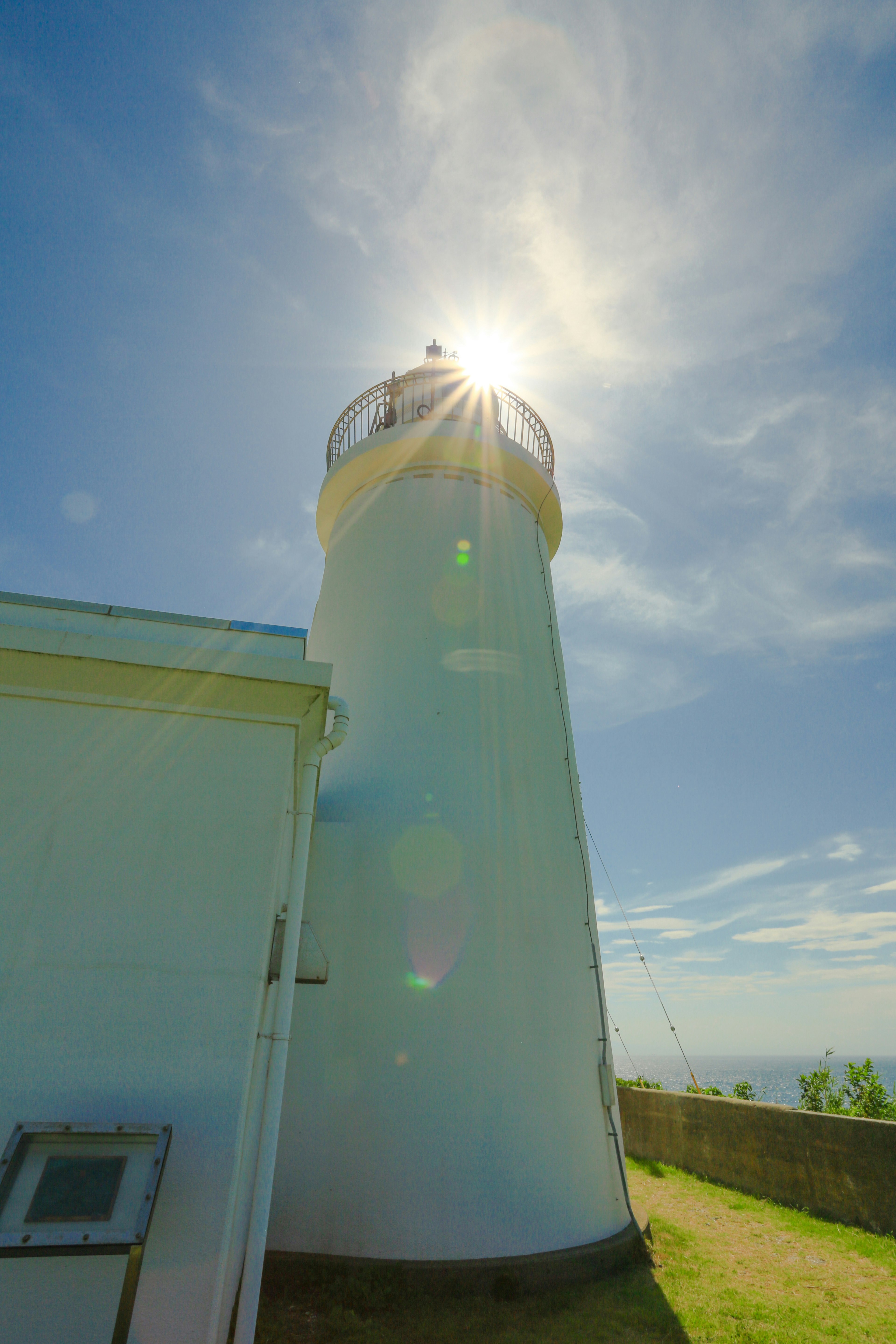 Un phare blanc se tenant sous un ciel bleu