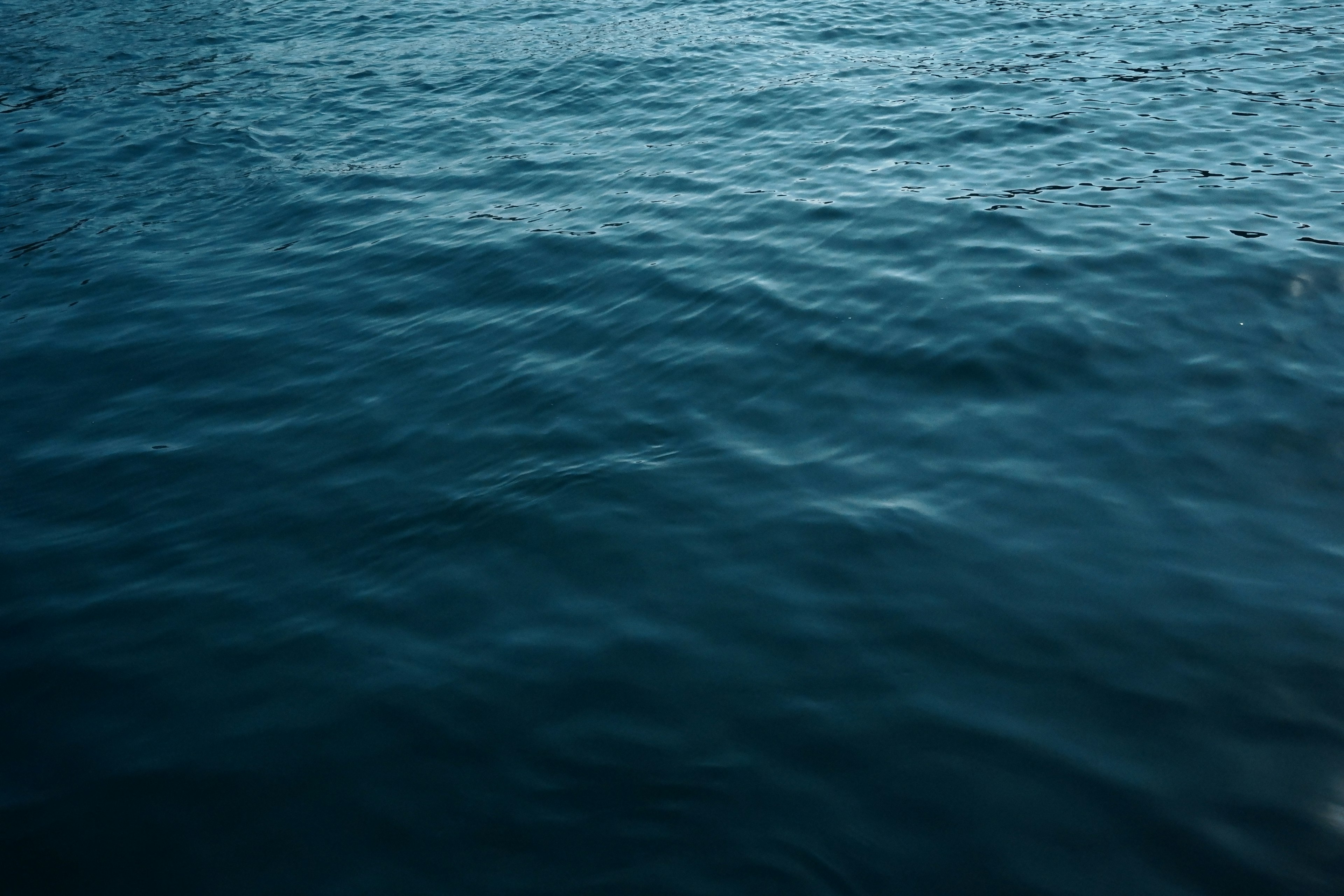 Close-up permukaan air laut biru yang tenang