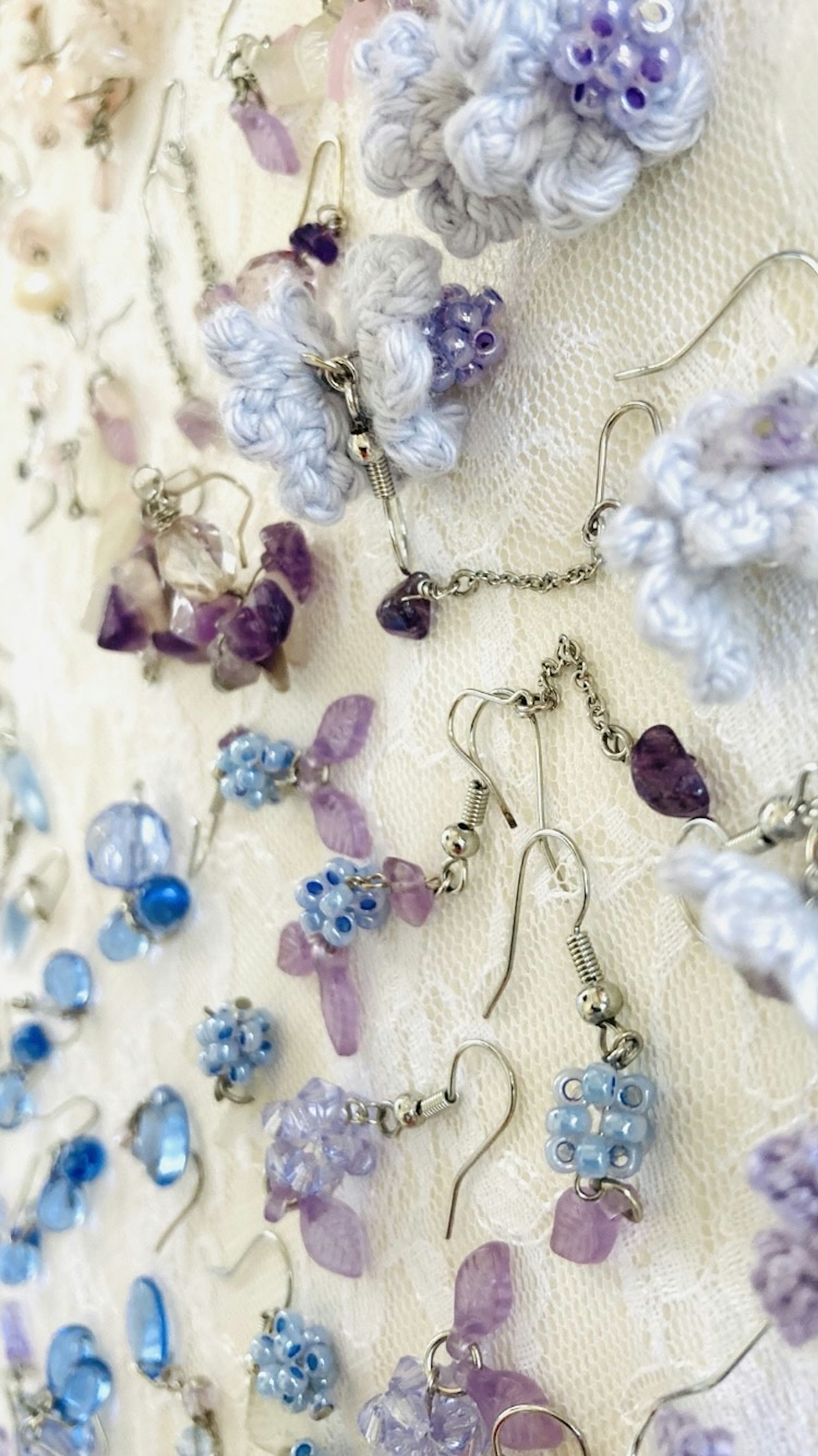 A display of colorful earrings and beads arranged on a textured background