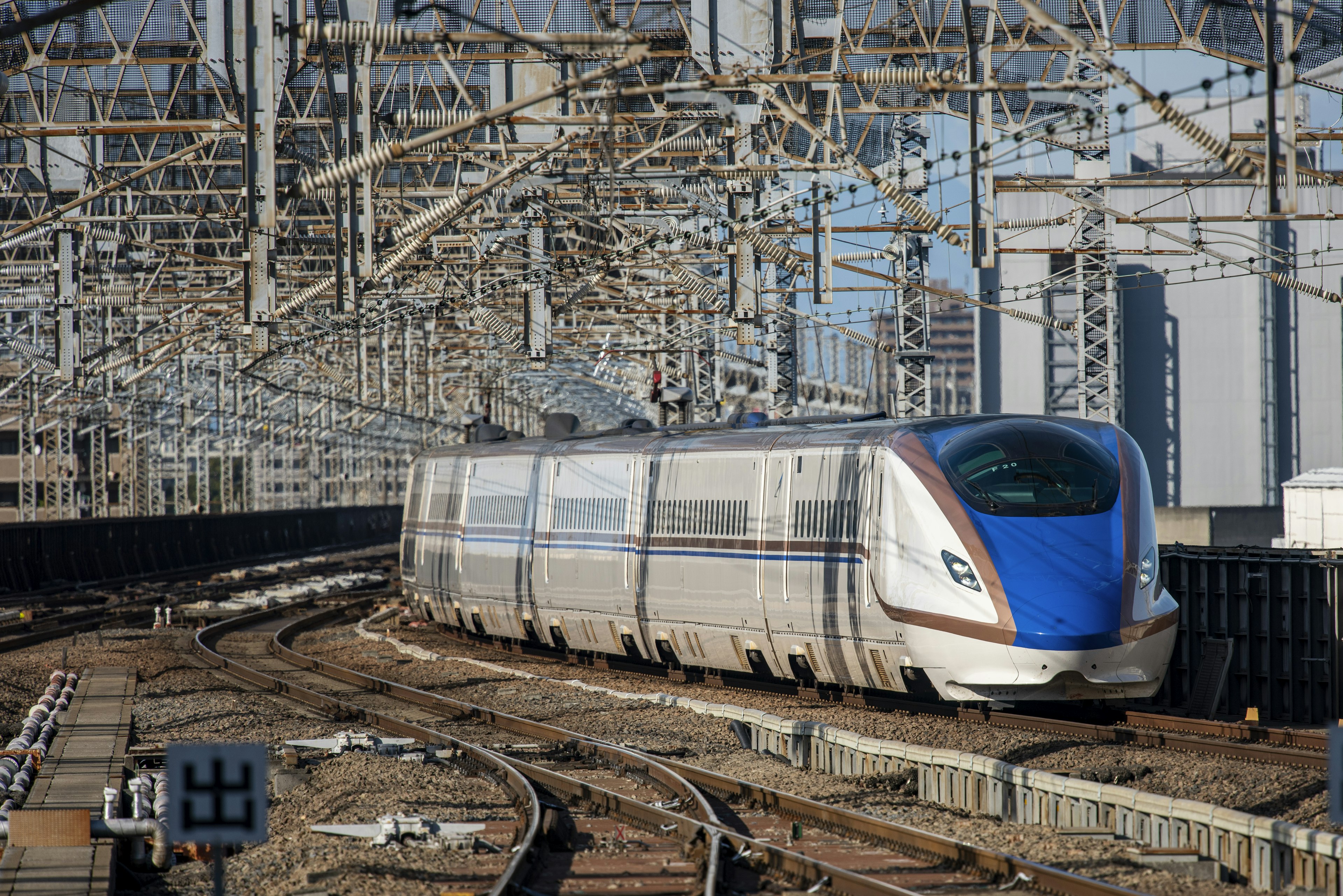 รถไฟชินคันเซนที่มีส่วนหน้าสีน้ำเงินวิ่งอยู่บนราง