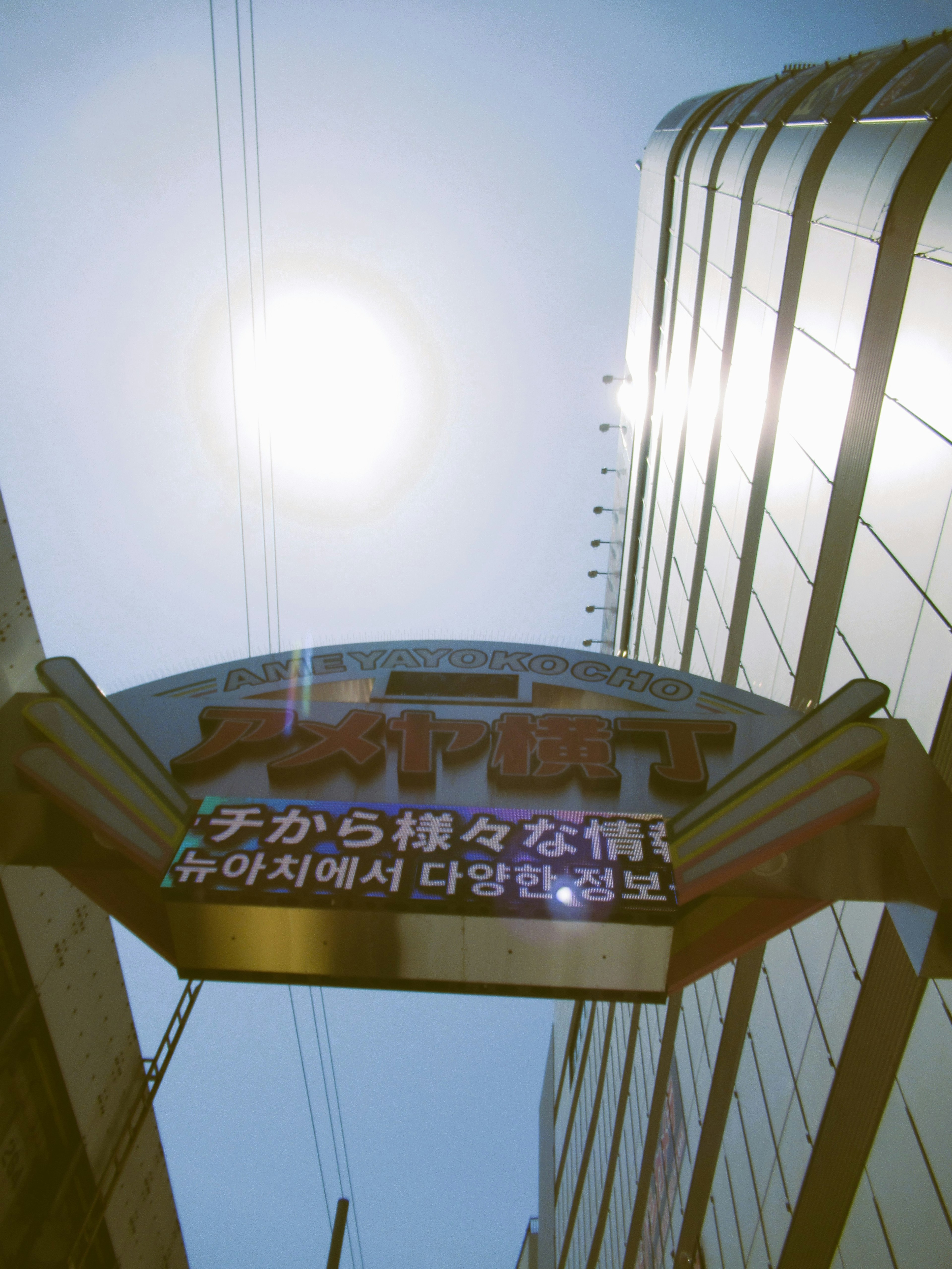 Imagen de un letrero de edificio con el sol brillando