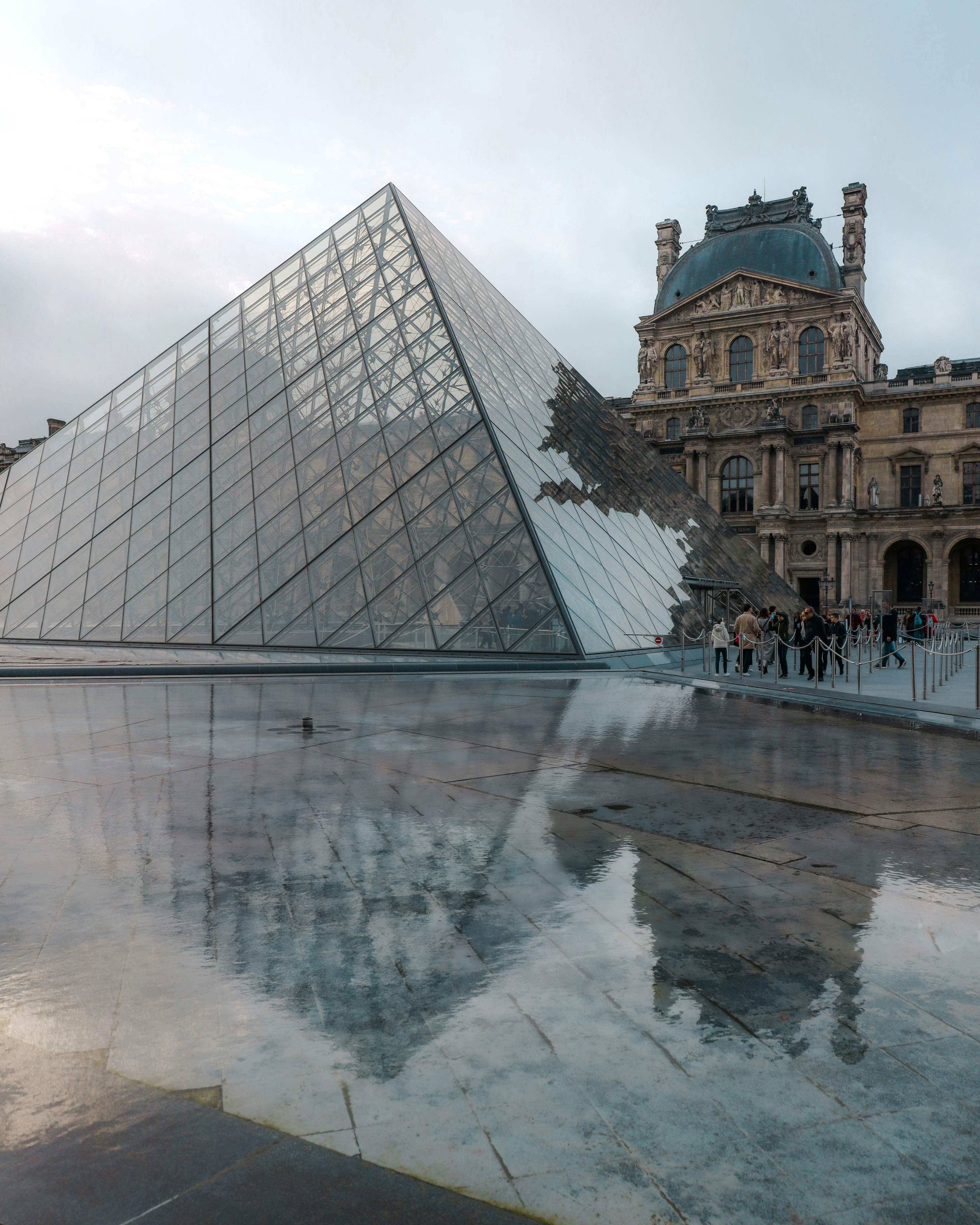 Glass pyramid of the Louvre Museum reflecting in water