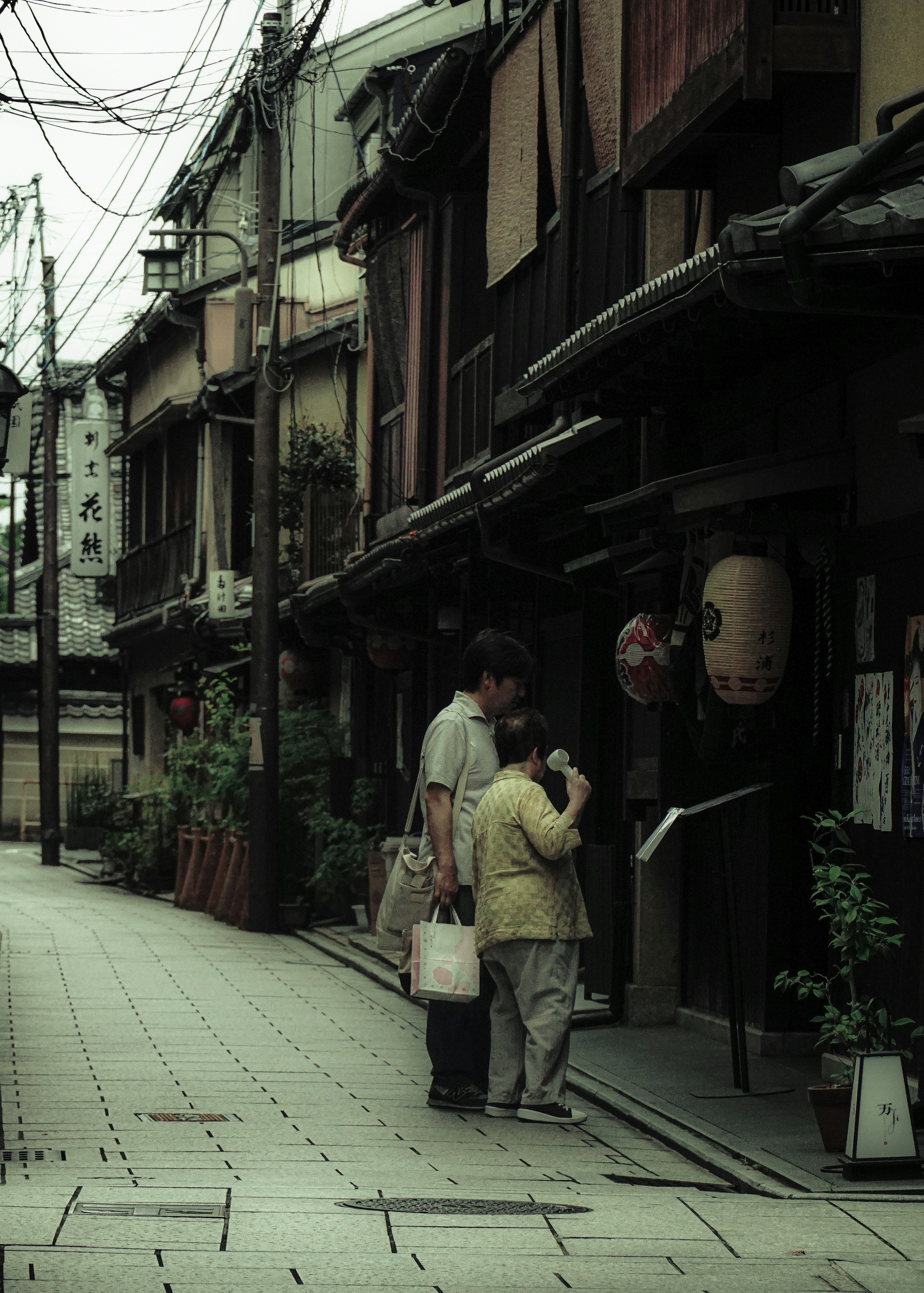 古い街並みで買い物をする人々と提灯が描かれた風景