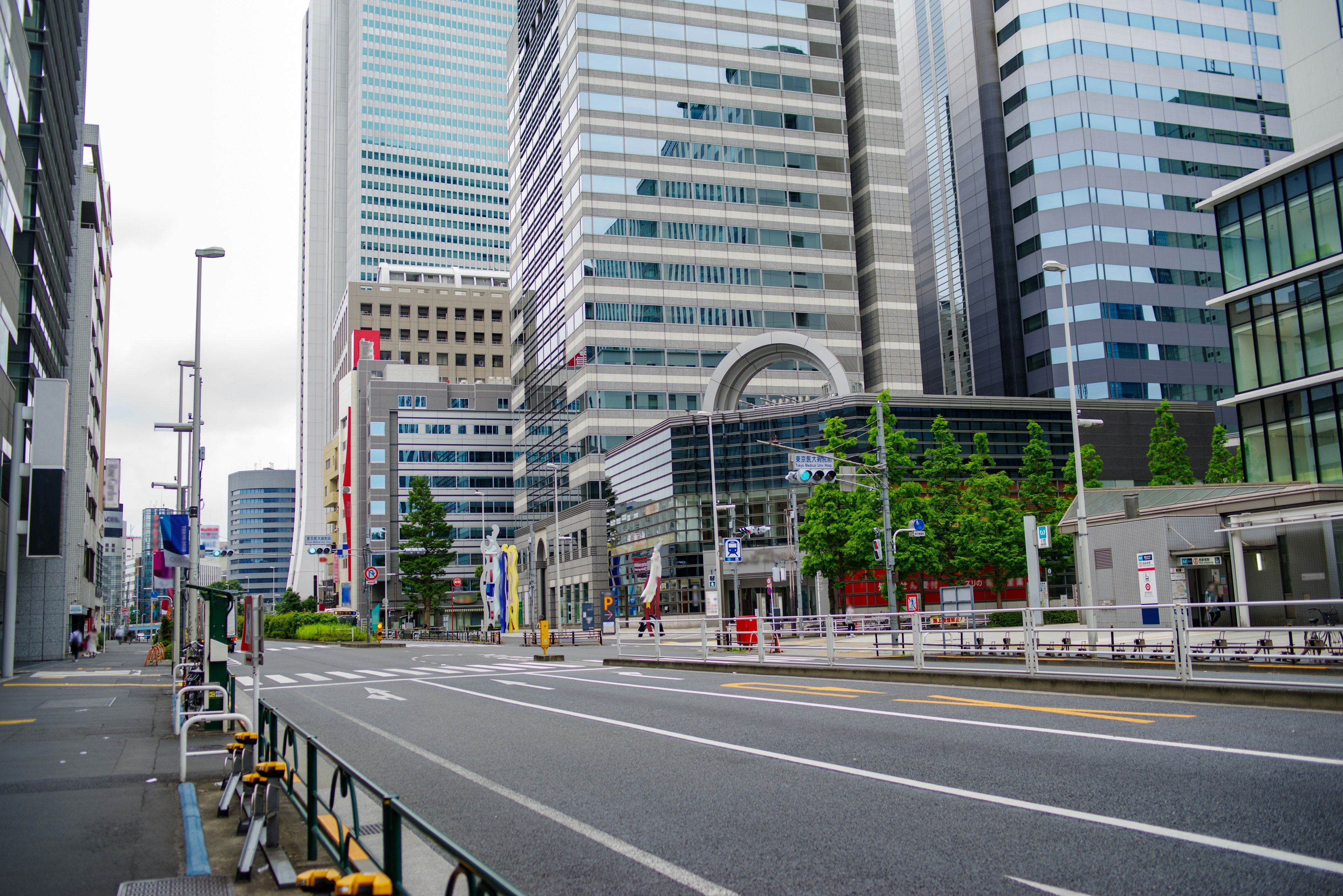 Jalan lebar dengan gedung tinggi dan langit mendung