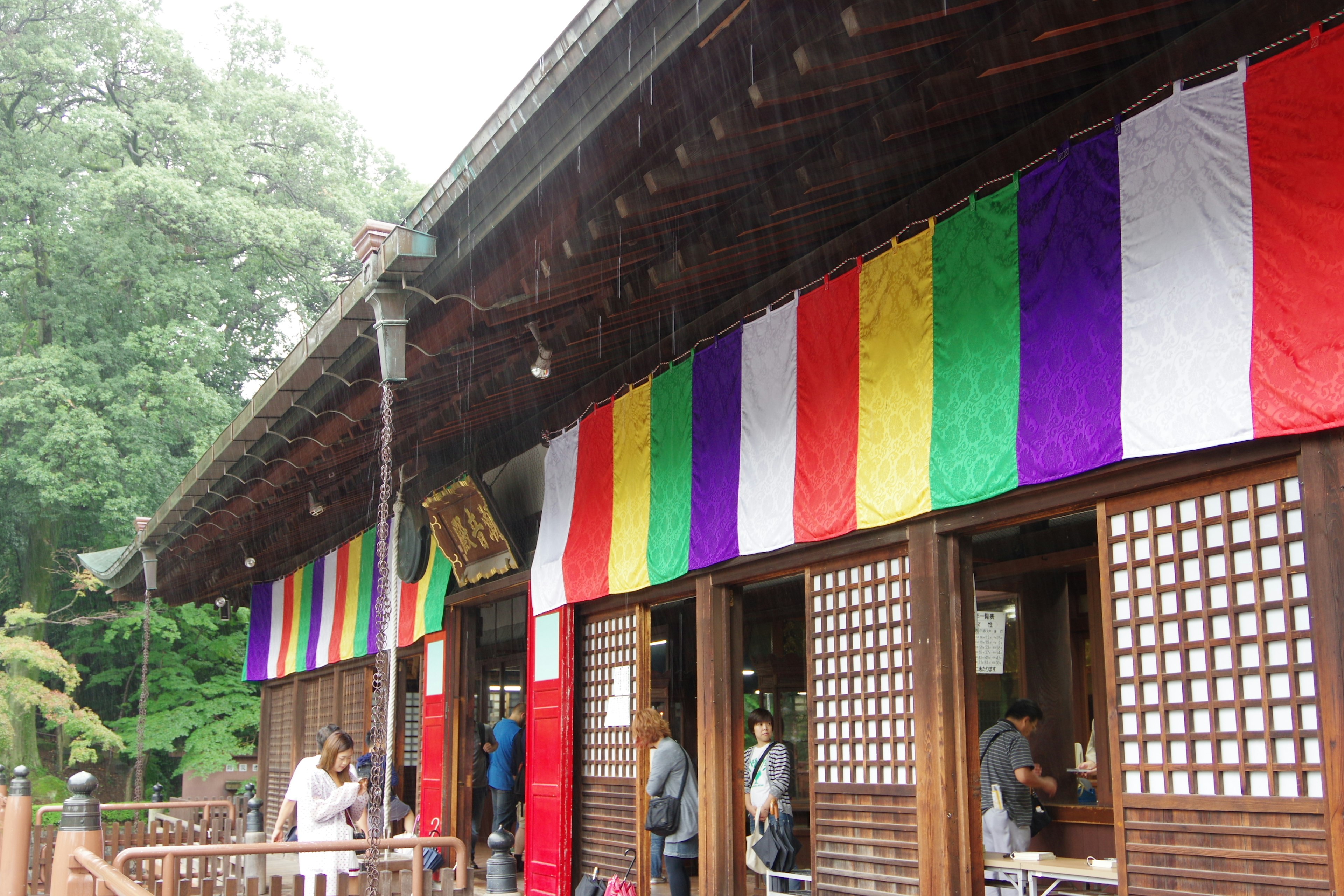 Exterior de un edificio tradicional adornado con telas coloridas personas entrando y saliendo