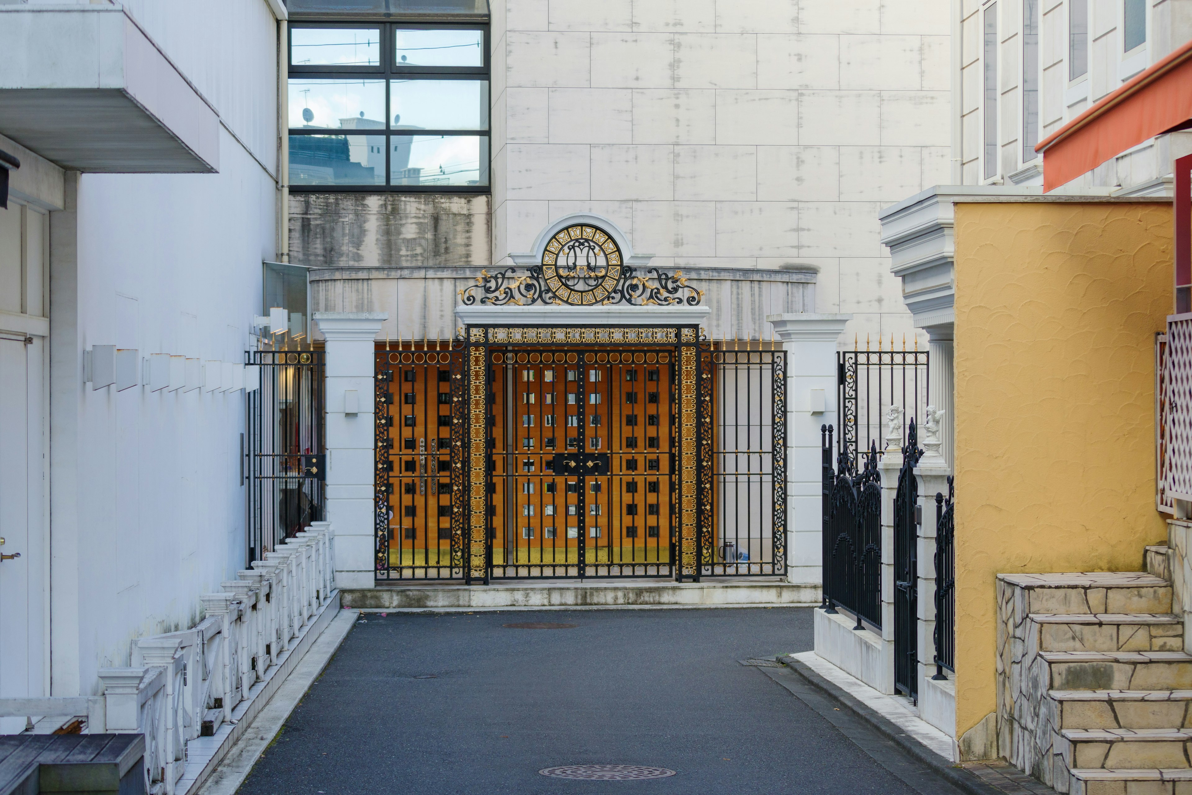 Entrada con puerta naranja y arquitectura moderna circundante