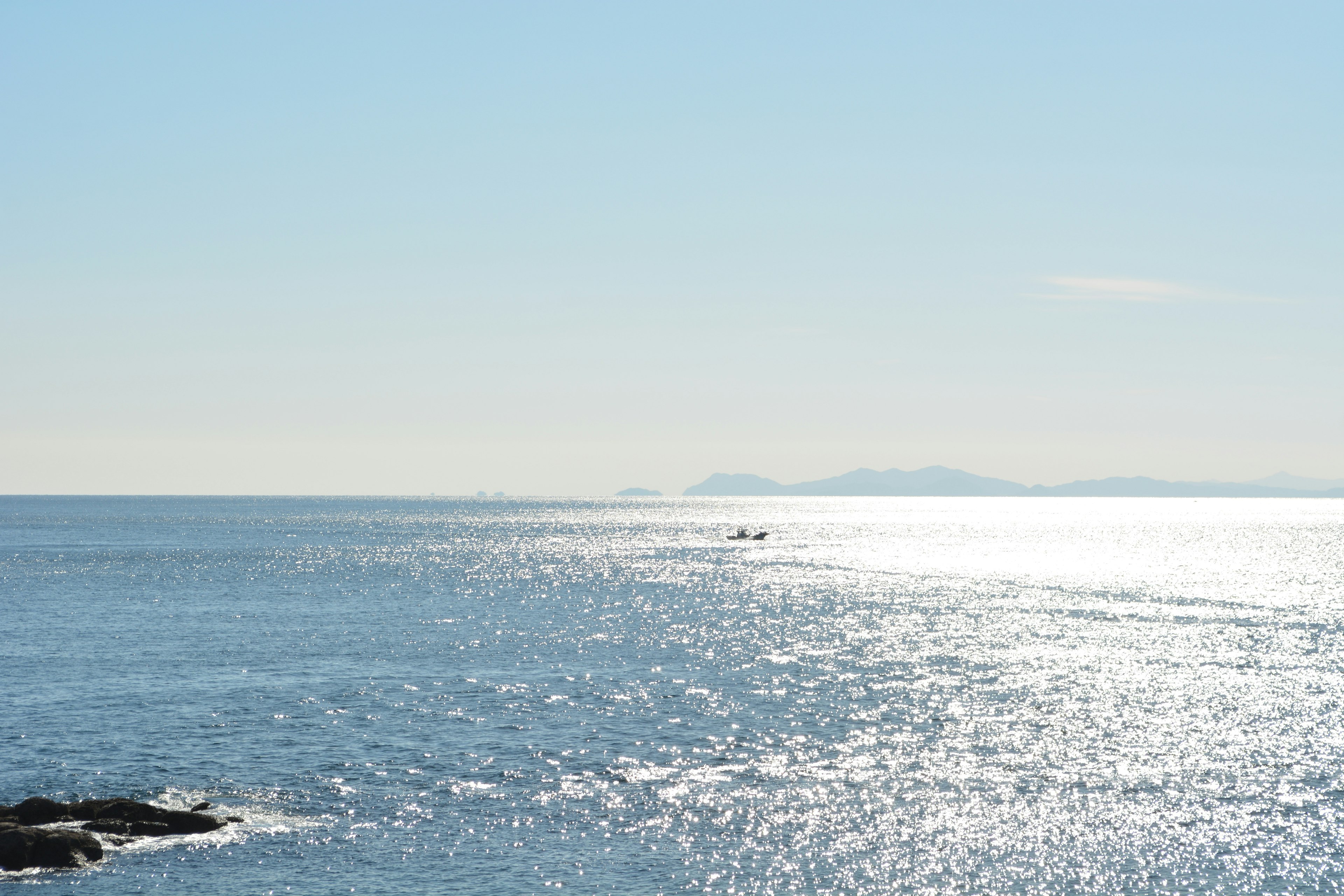 寧靜的海景，藍色水面和明亮的天空，遠處可見島嶼