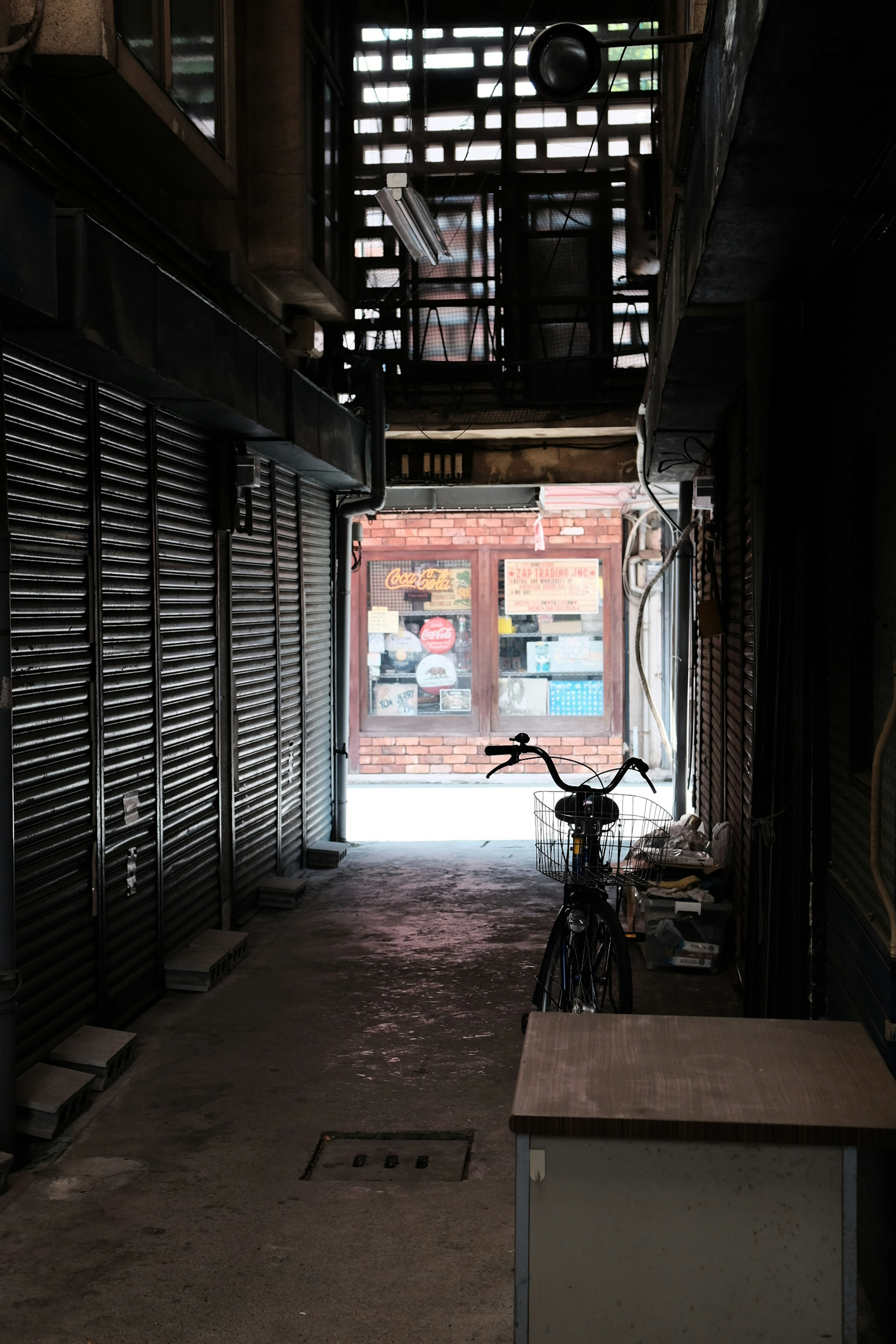 Callejón estrecho con una bicicleta aparcada Salida brillante y persianas visibles