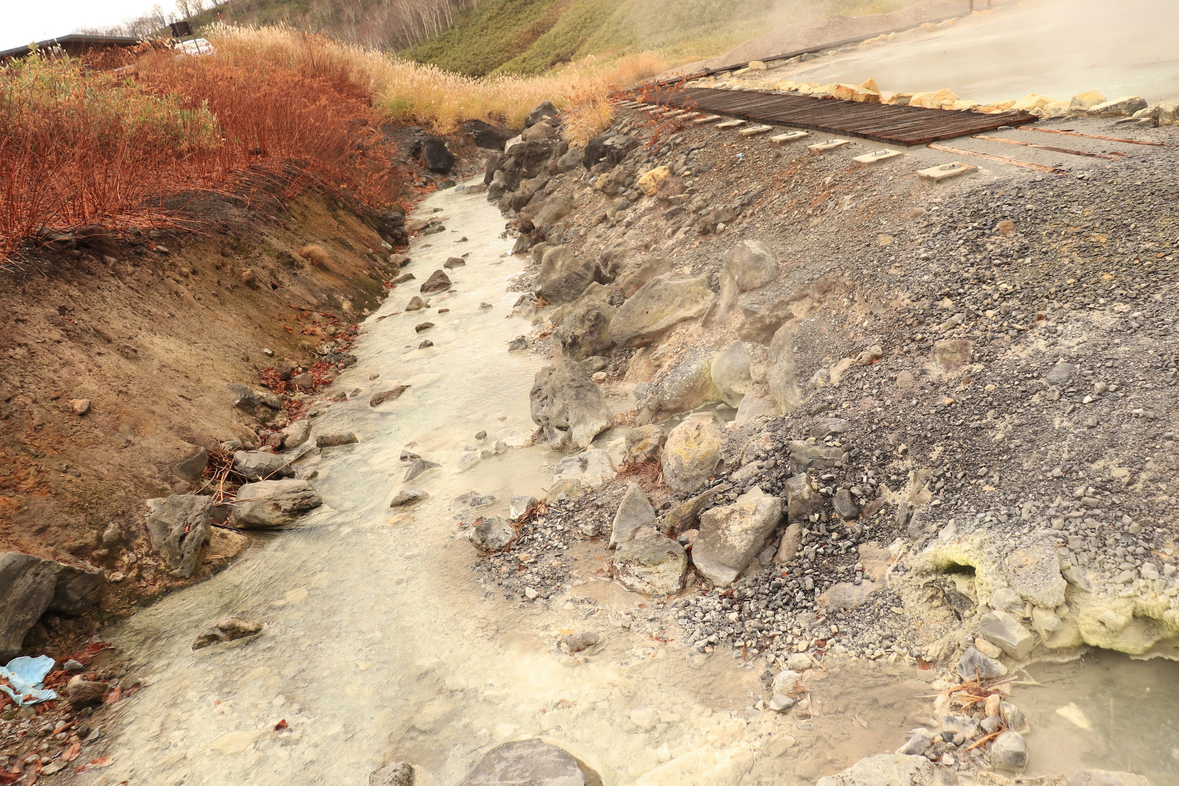 A rugged landscape featuring a small stream and scattered rocks