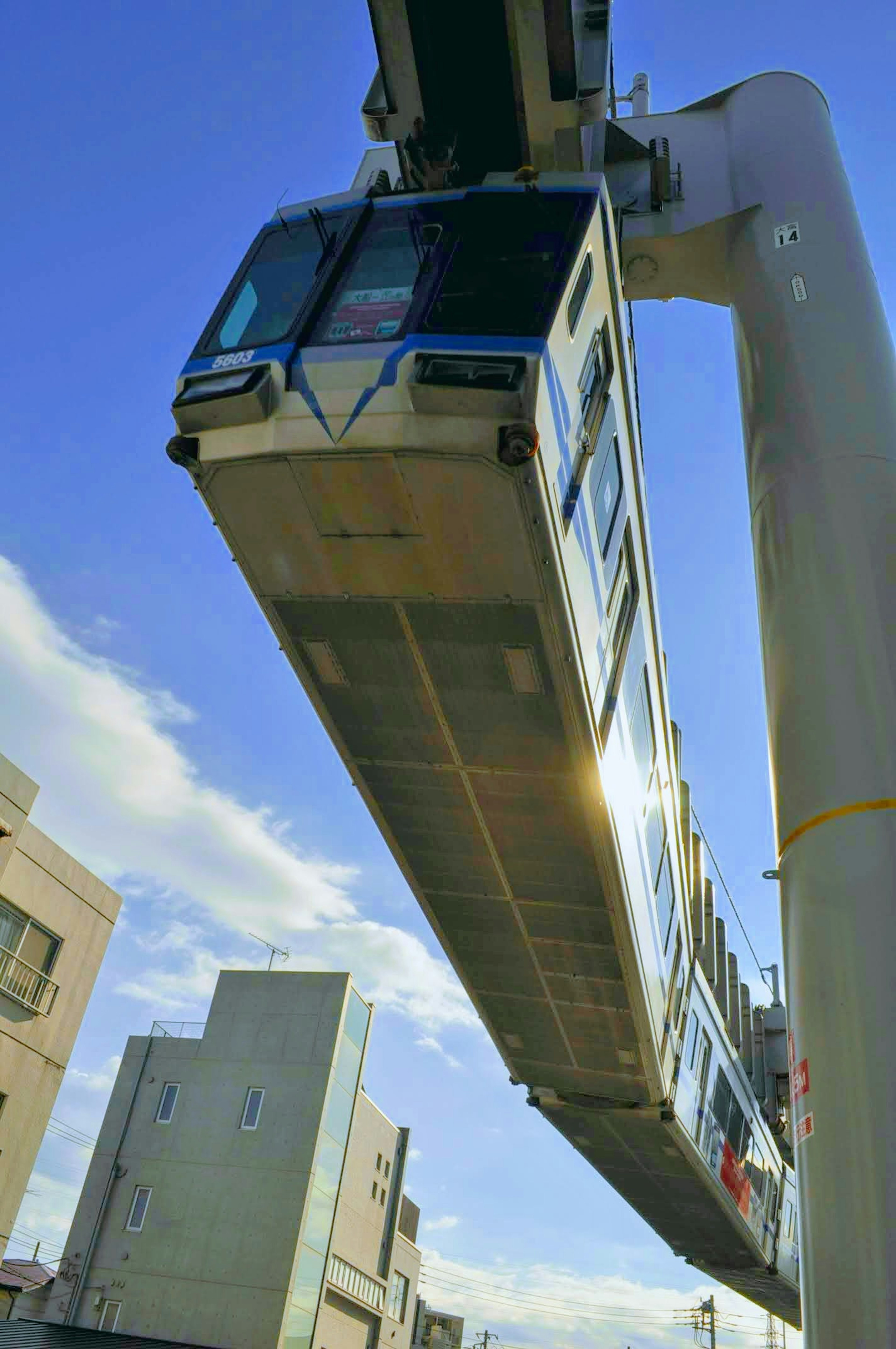 Un treno monorotaia sospeso nel cielo sopra un paesaggio urbano