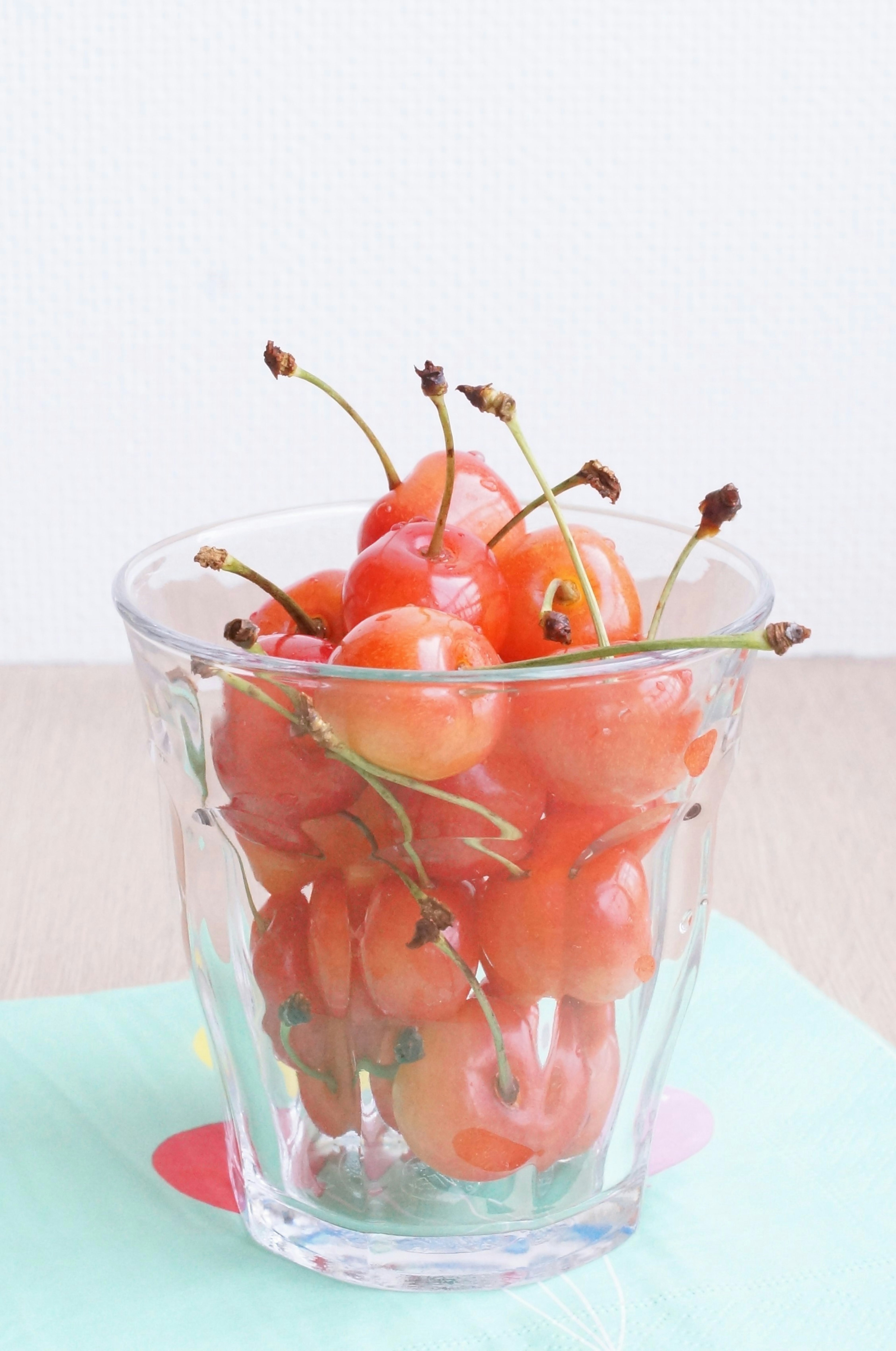 Cerezas rojas en un vaso transparente