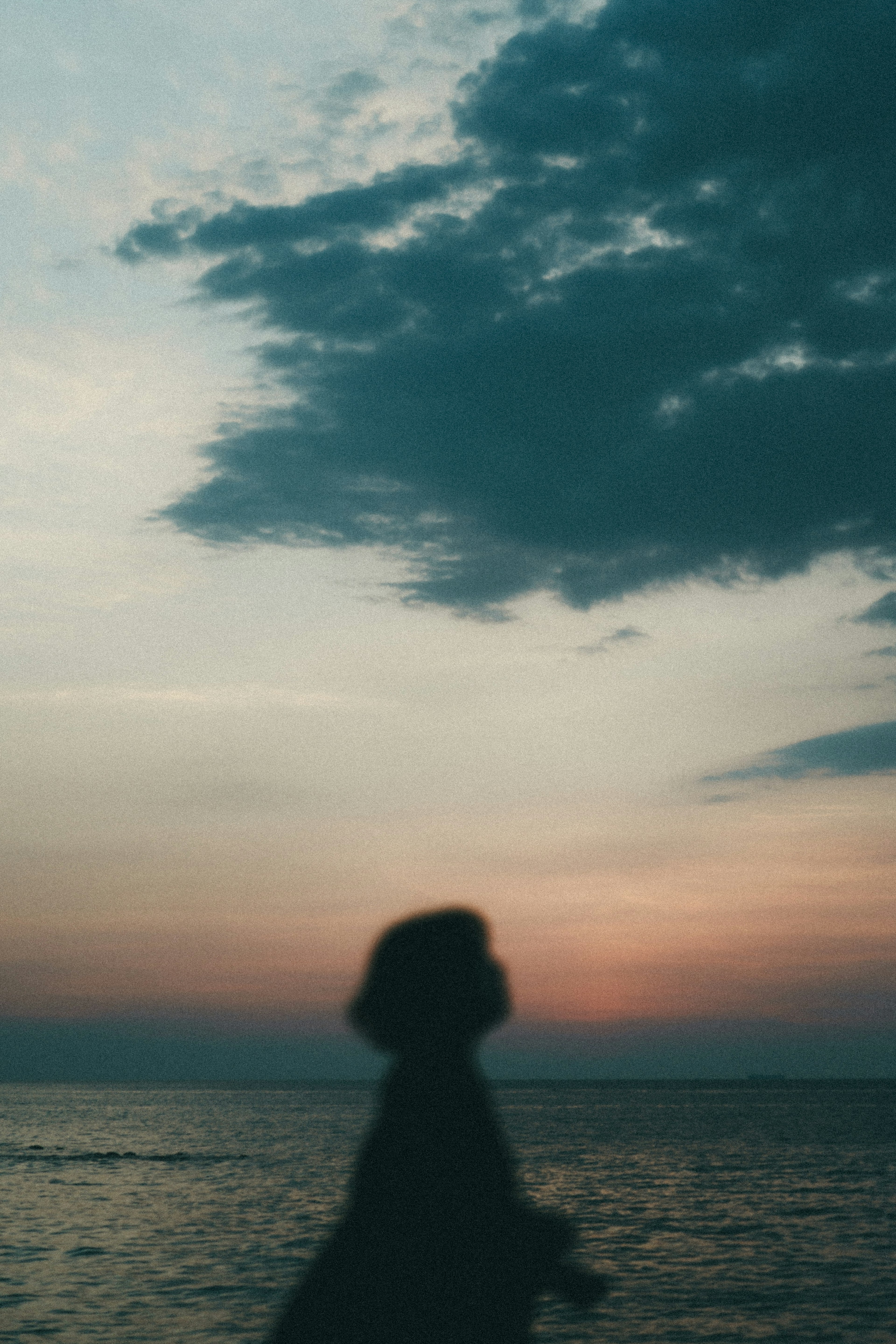 Silueta de una persona caminando por la playa al atardecer