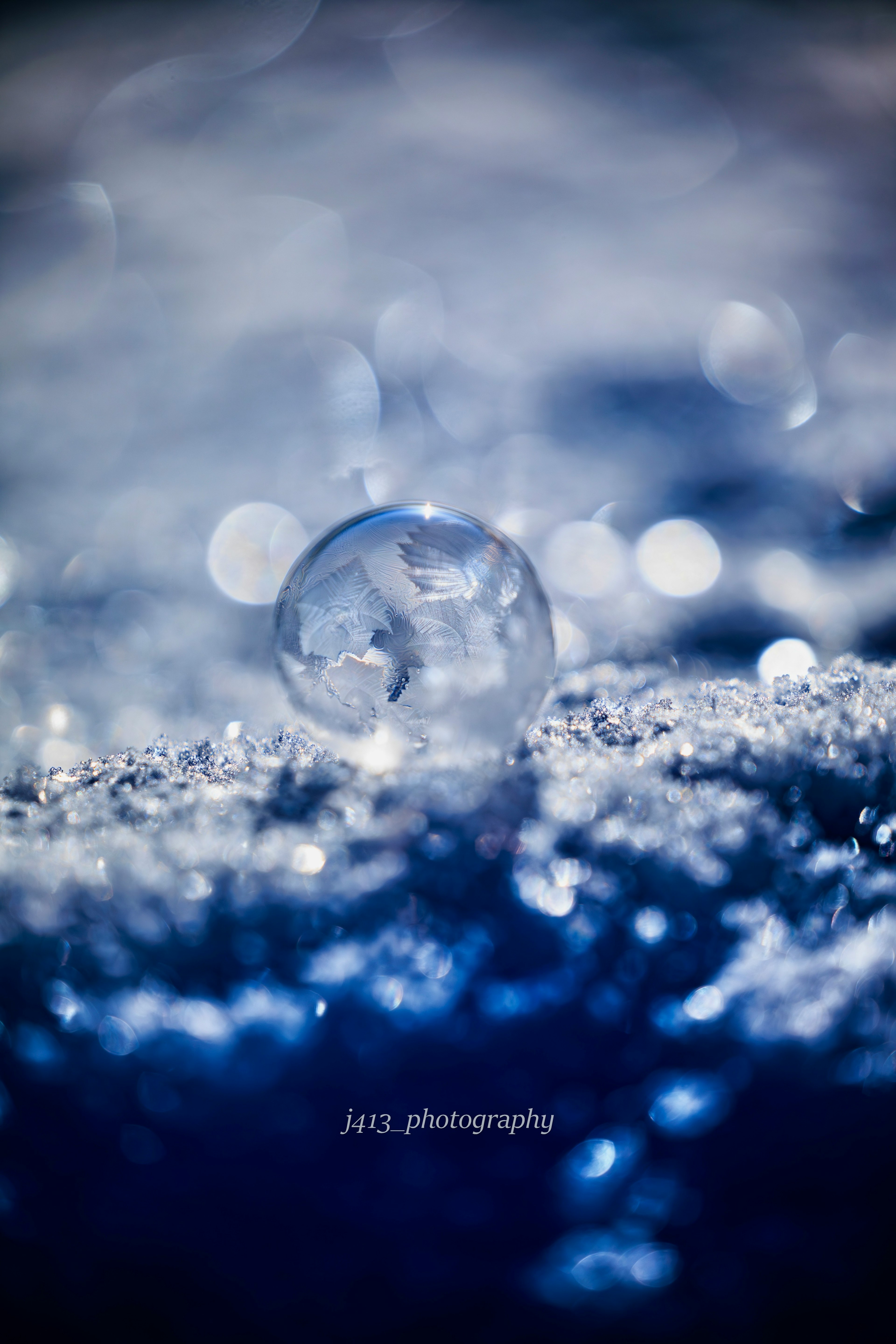 氷の球体が青い背景の上に浮かんでいる美しいマクロ写真