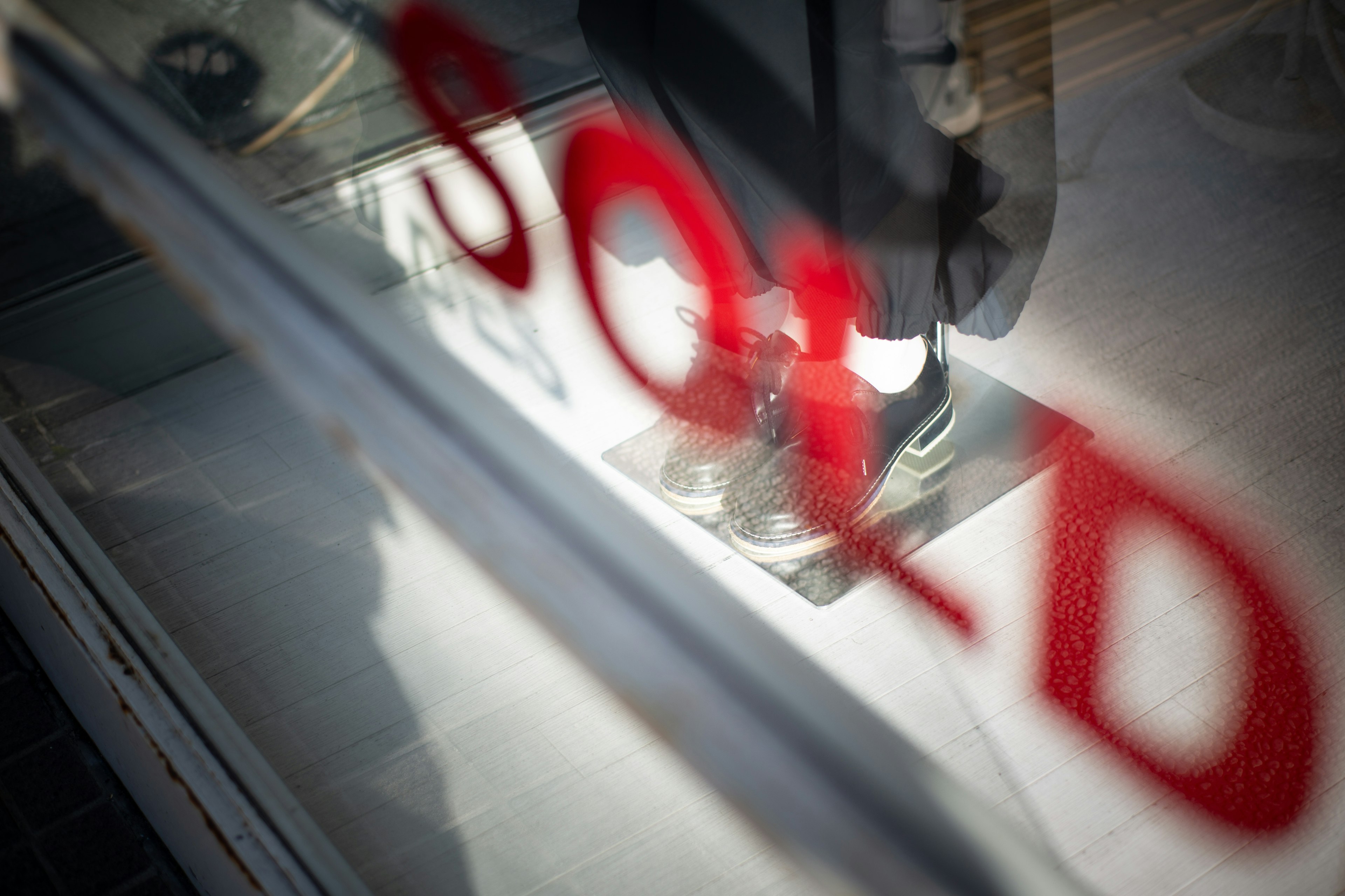 Una vetrina che mostra scarpe vendute con un grande cartello rosso "SOLD"