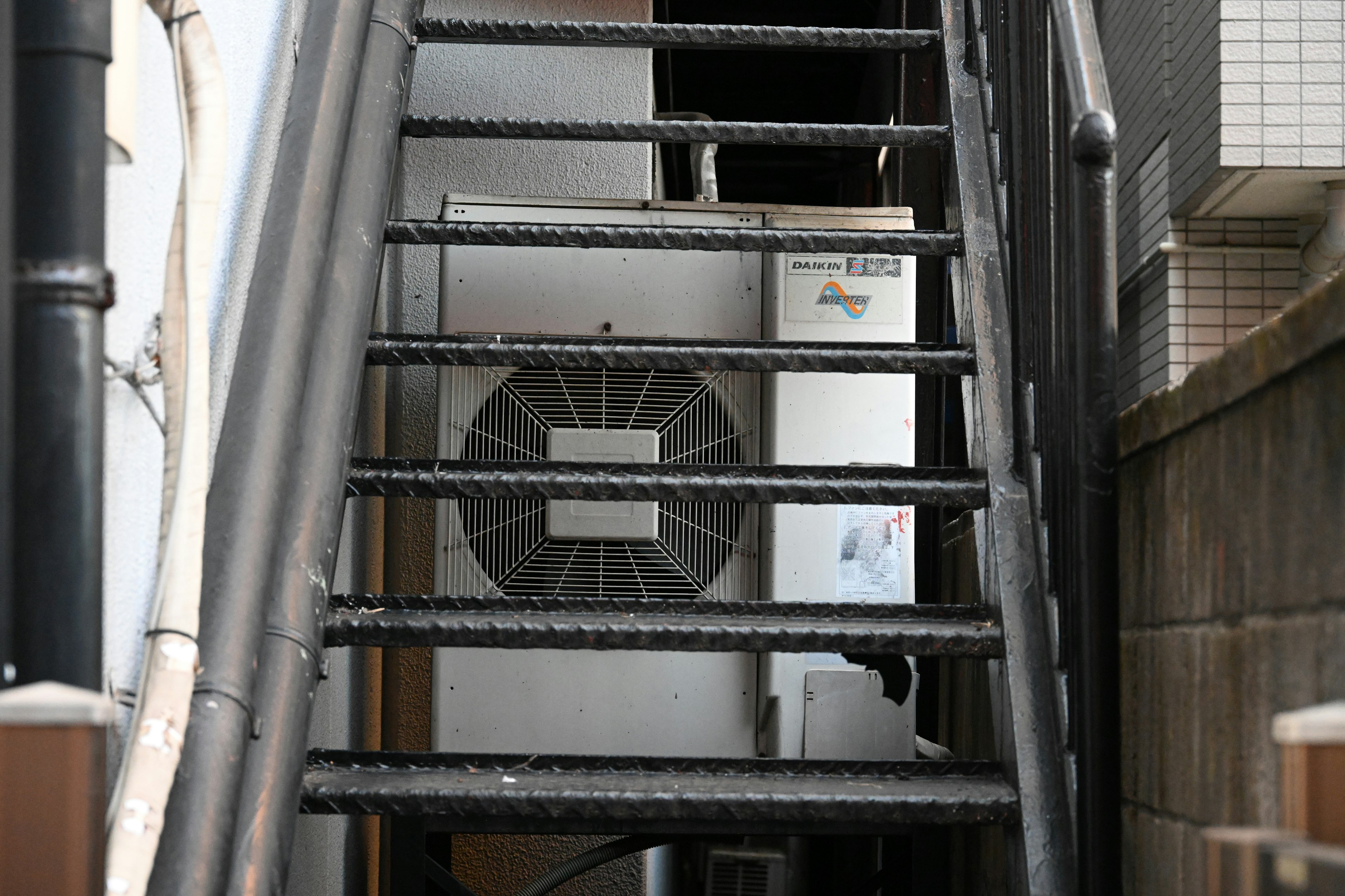 A view of stairs with an air conditioning unit in the background