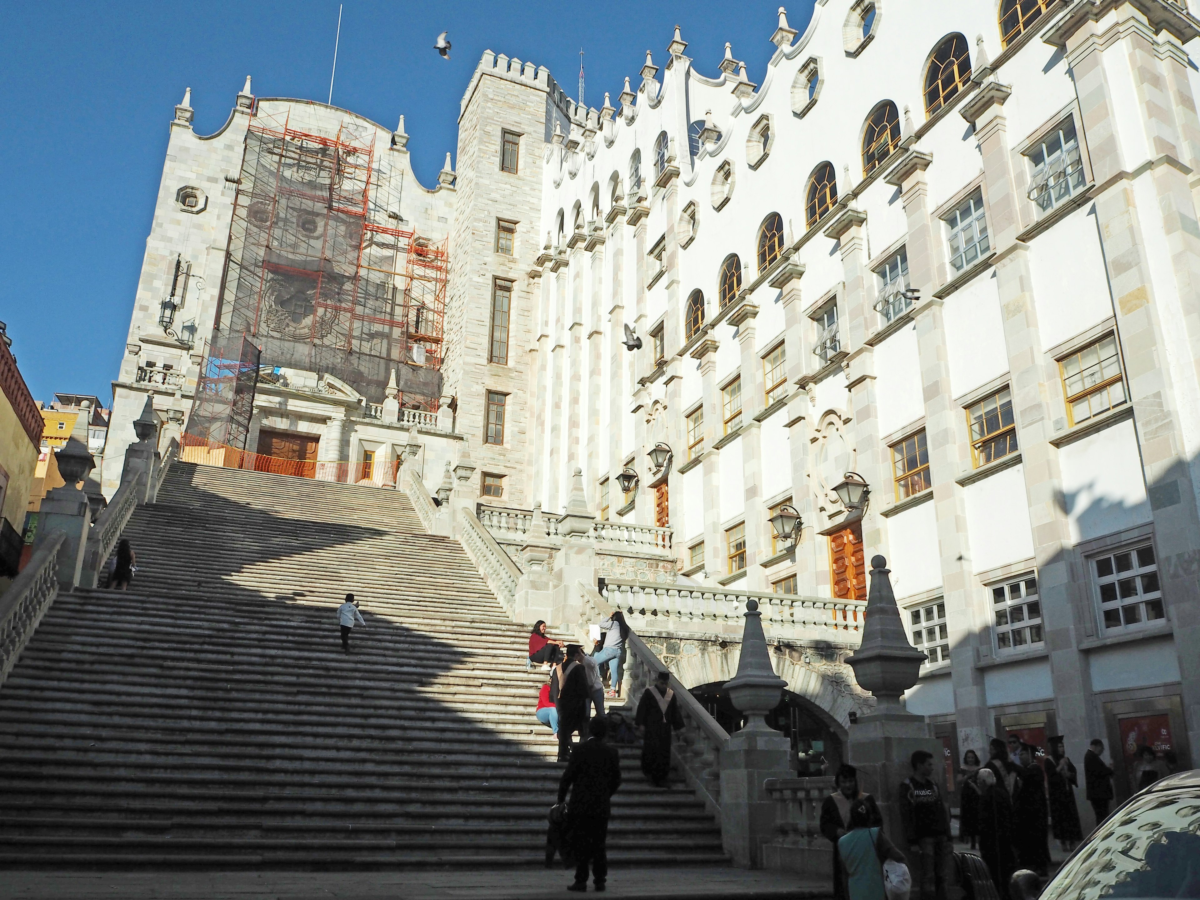 Piazza storica con un grande edificio bianco e una scala prominente