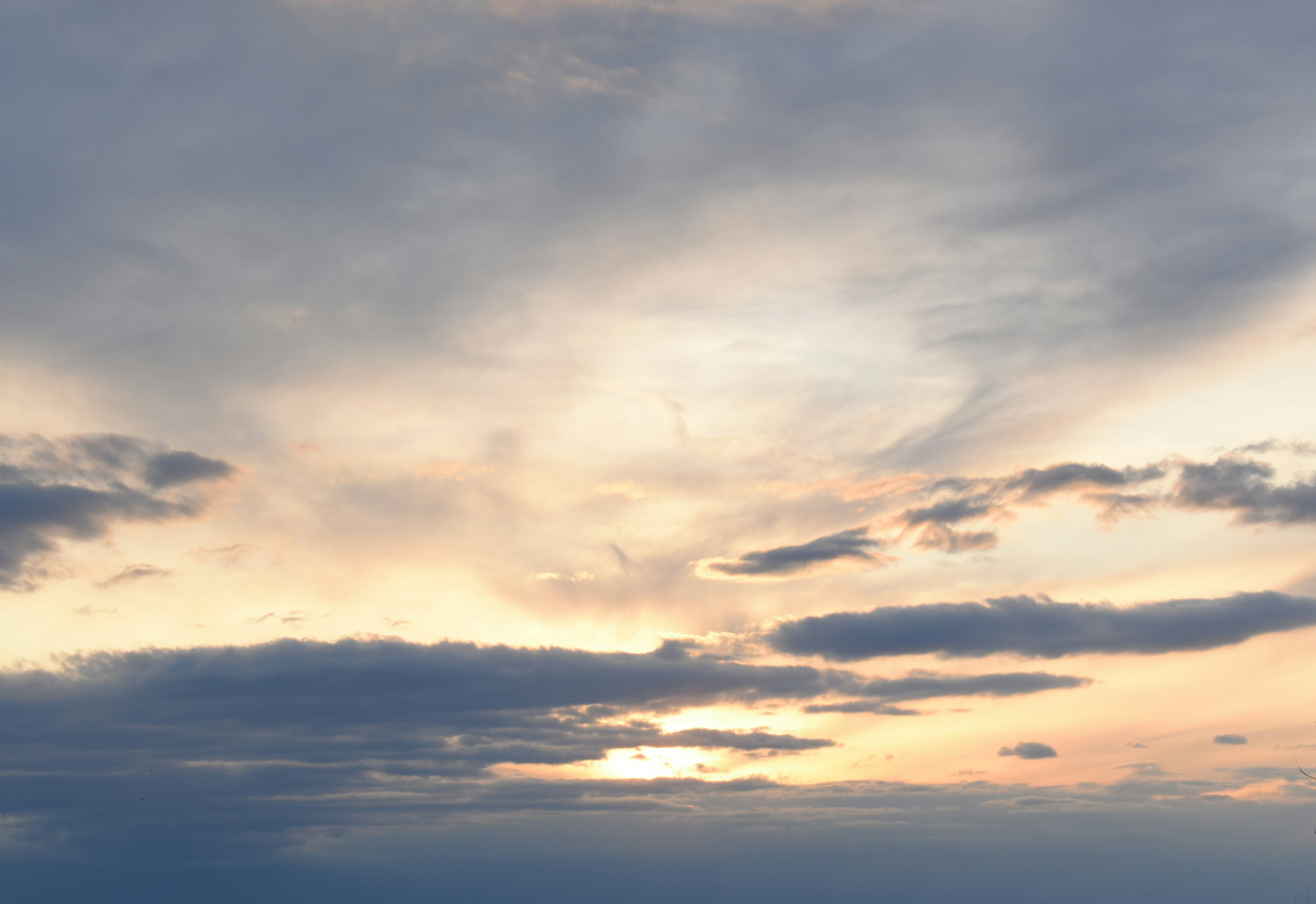 Un cielo sereno al atardecer con nubes de colores suaves