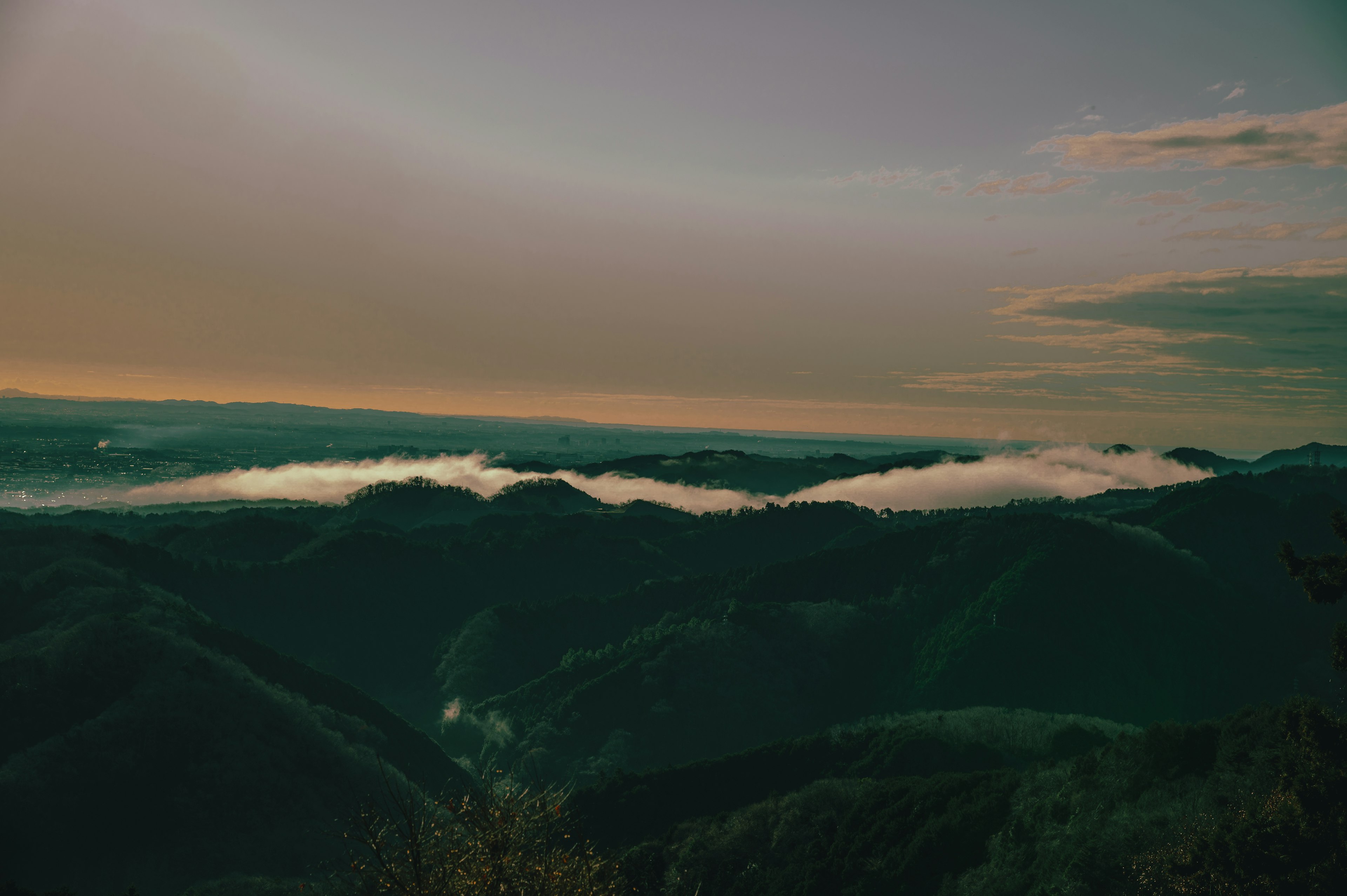 Kabut yang menyelimuti bukit di bawah langit senja