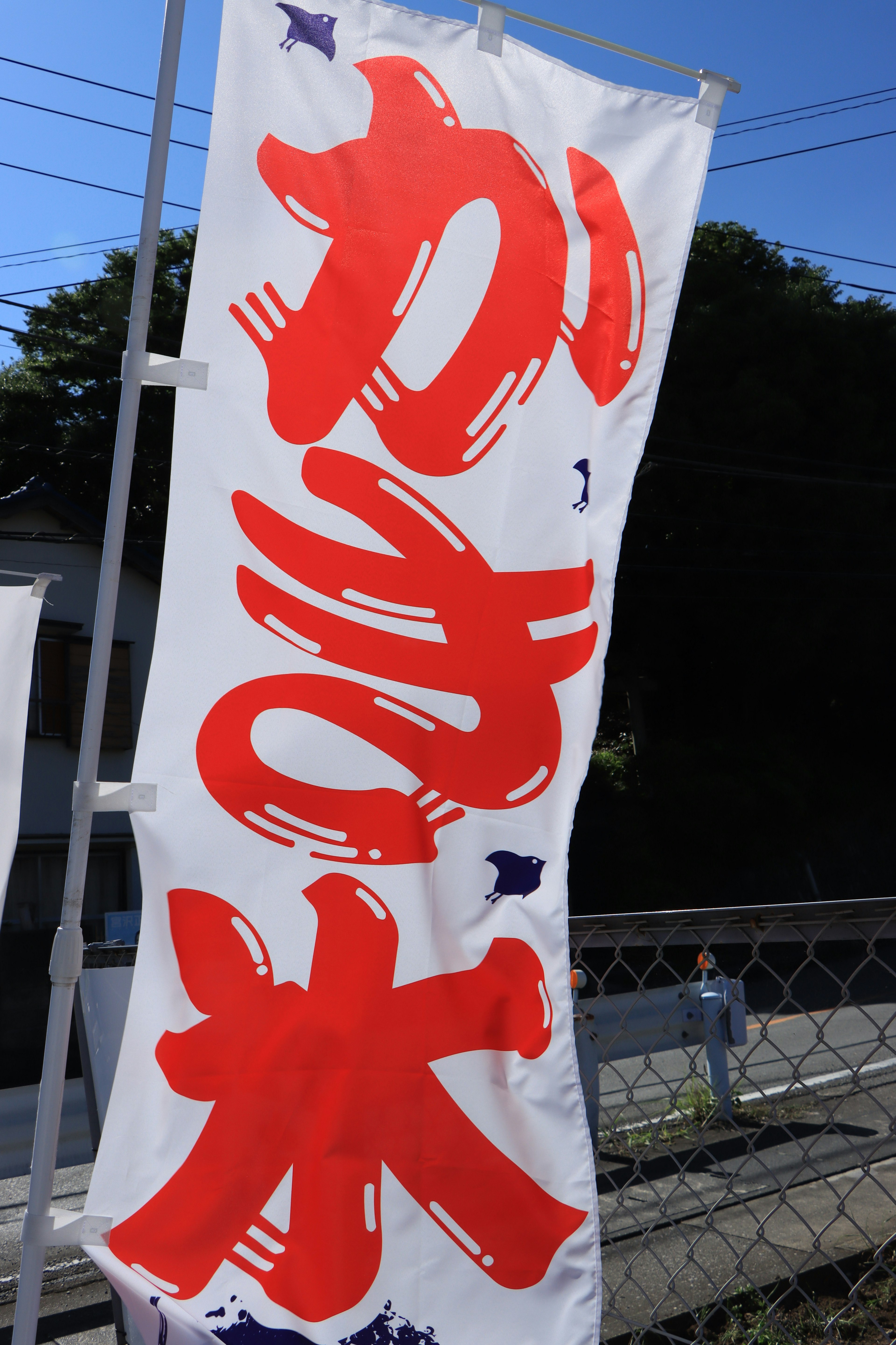 A banner displaying the word 'Kakigori' in bold red letters against a clear blue sky