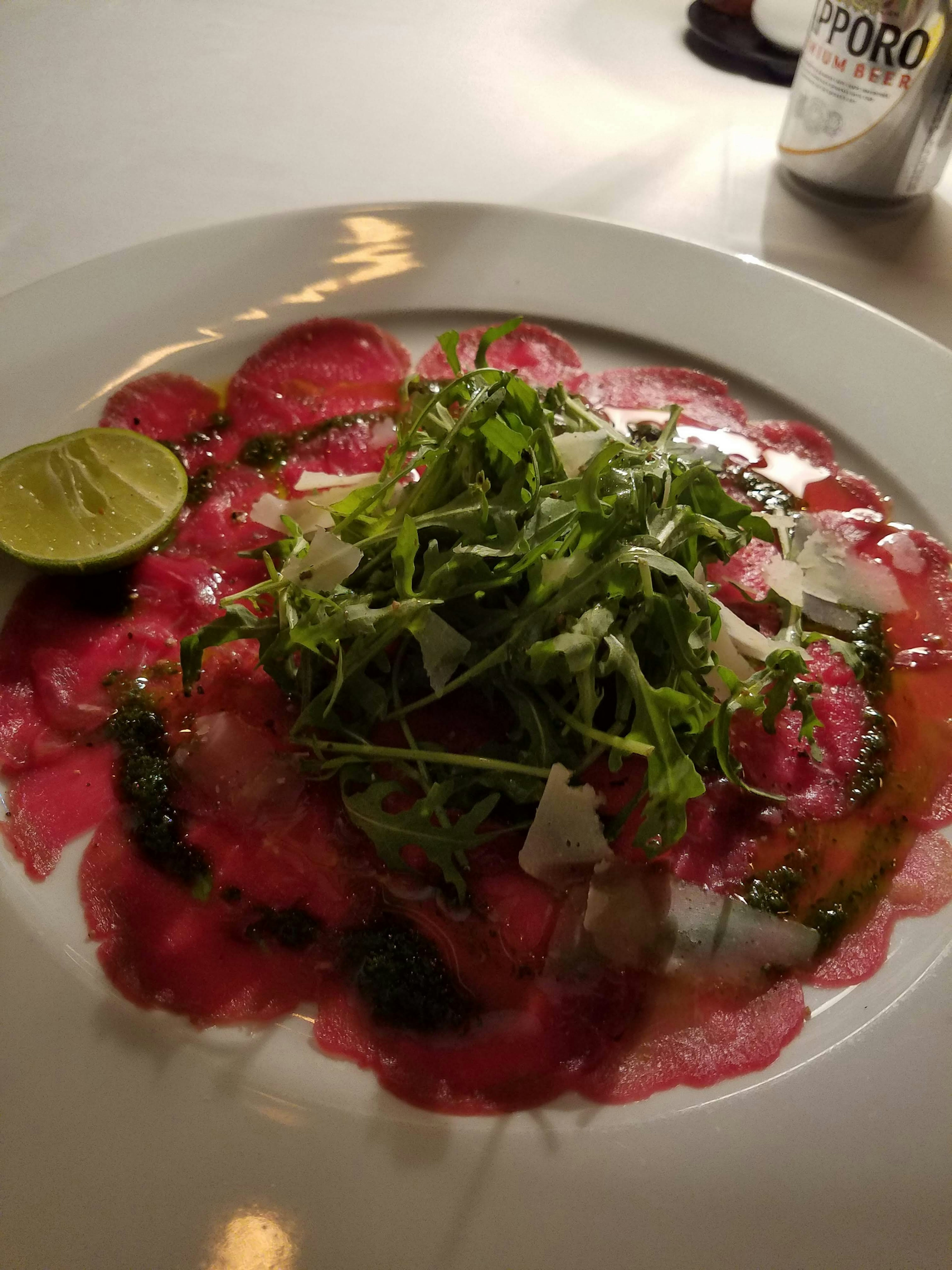 Carpaccio cerah dengan hiasan jeruk nipis dan herba