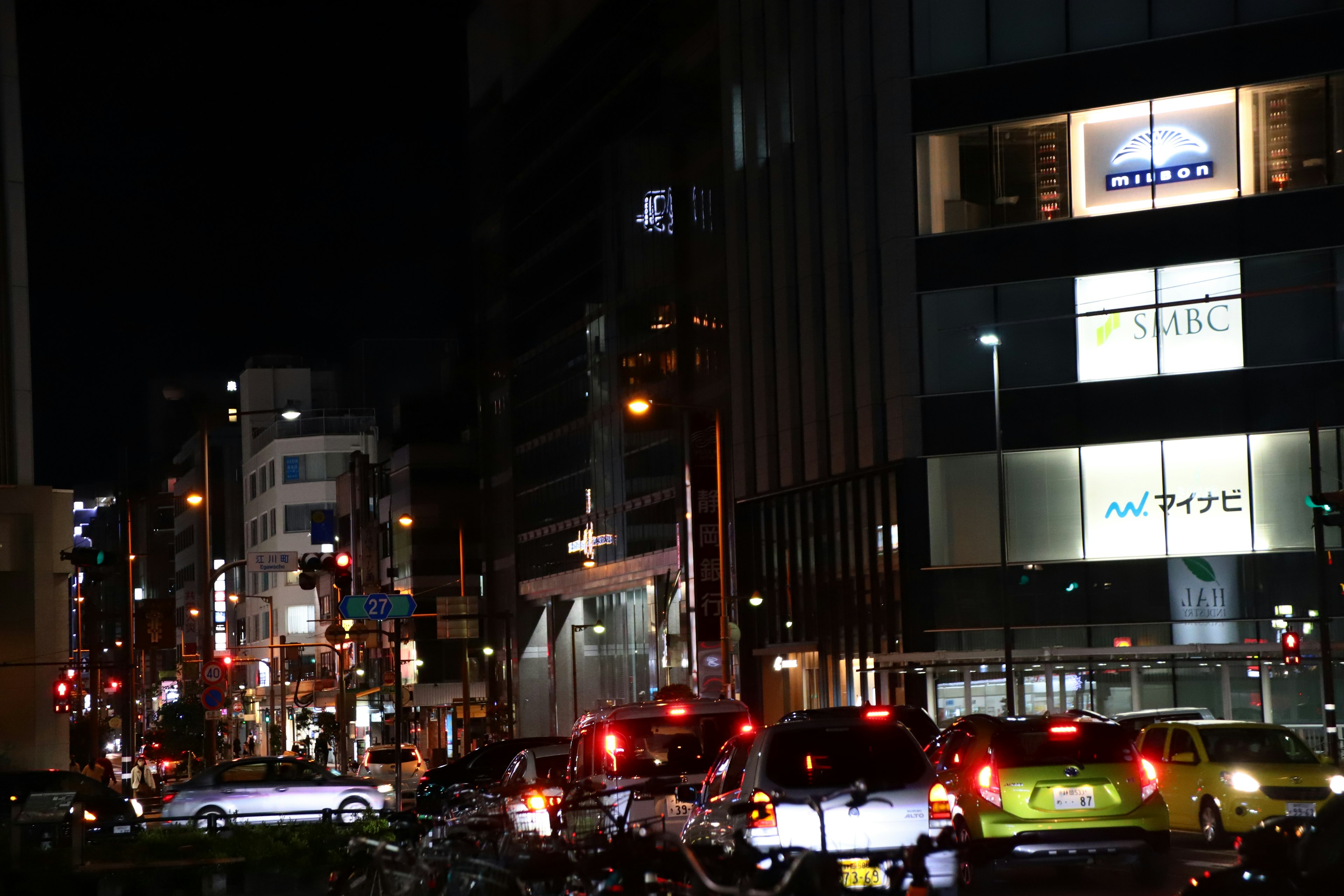 Pemandangan kota di malam hari dengan lalu lintas ramai dan gedung-gedung yang diterangi