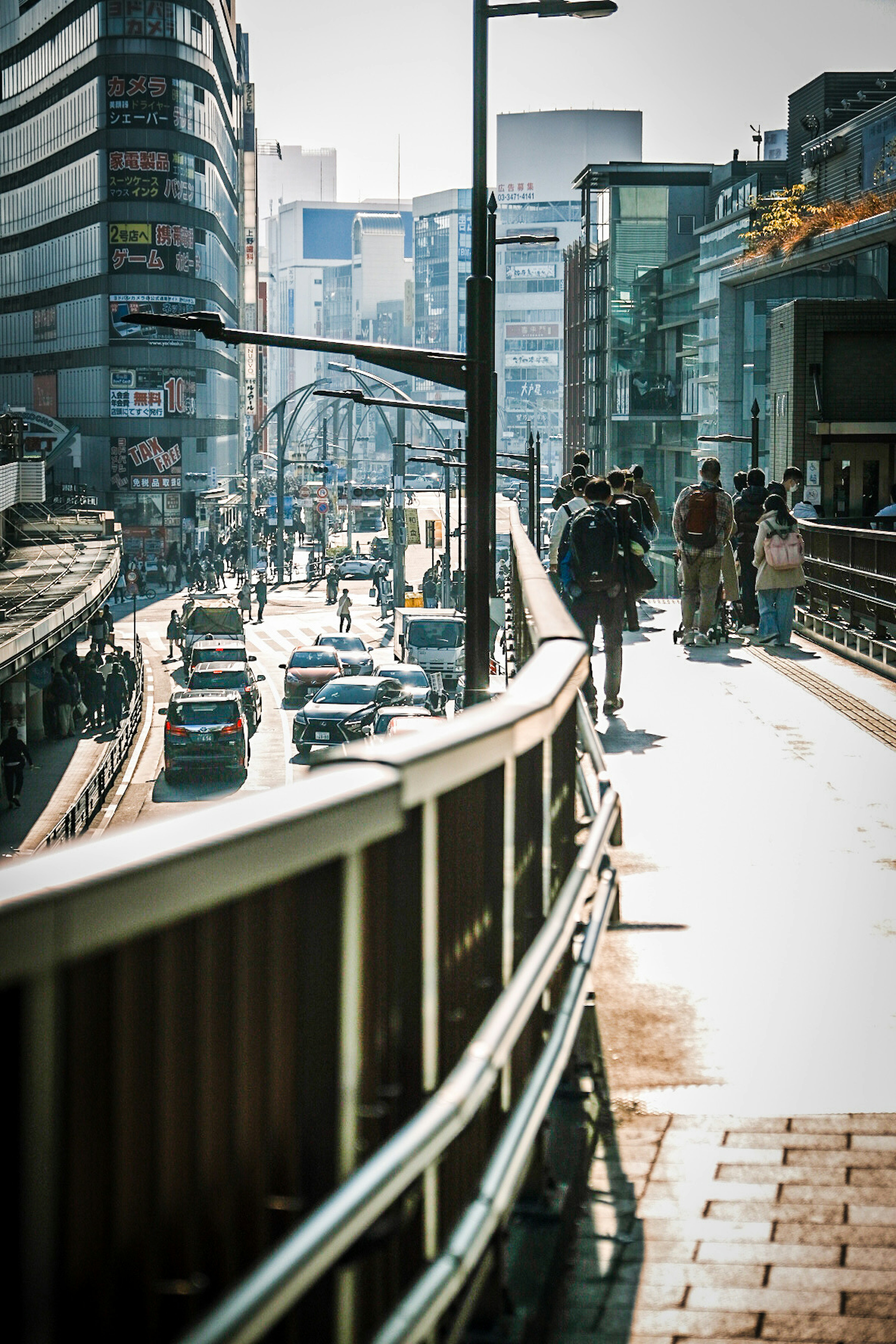 Cityscape showing pedestrians on a bridge with traffic below