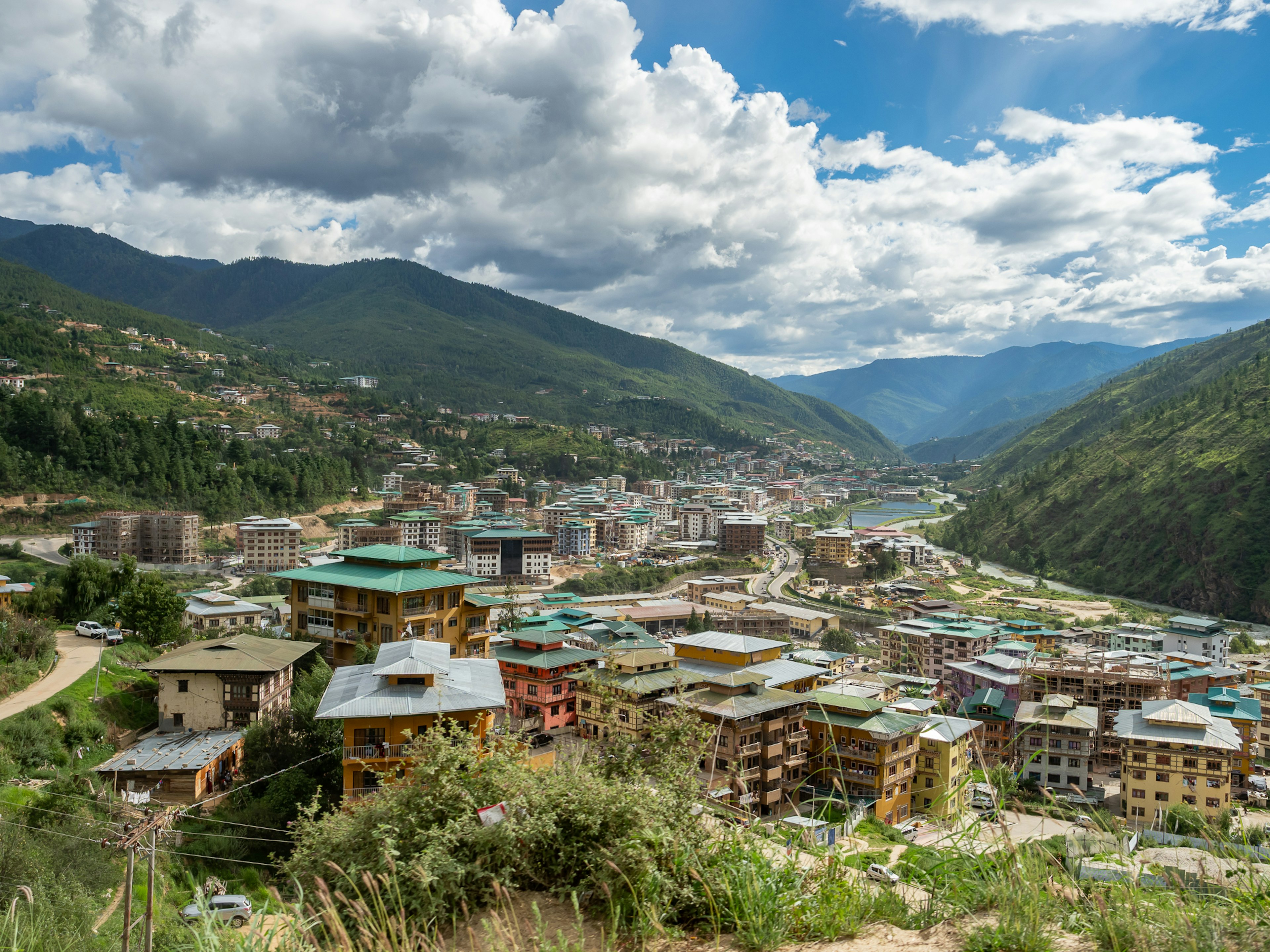 Pemandangan Thimphu di Bhutan dikelilingi oleh gunung hijau langit biru dan awan putih