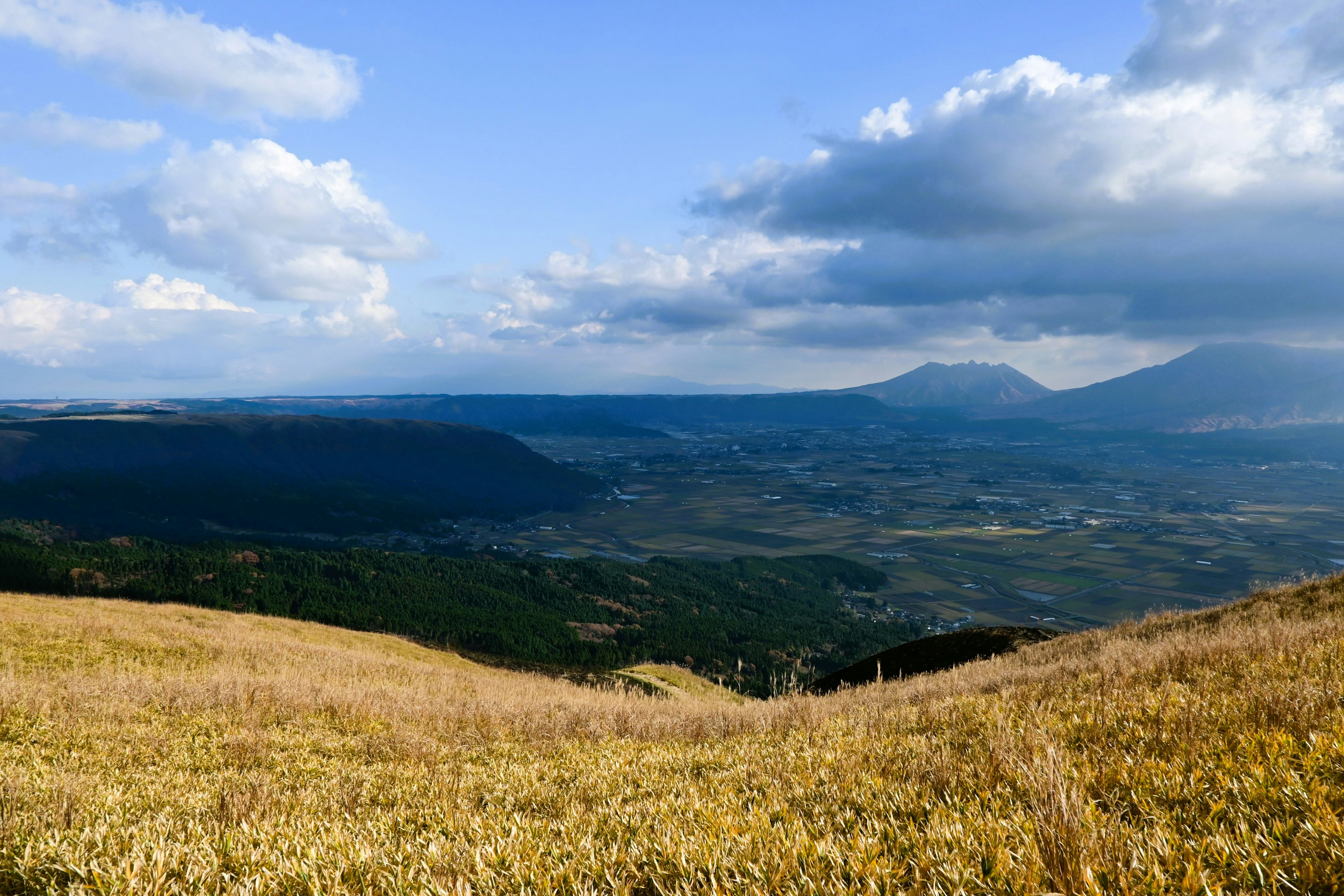 Scenic landscape with blue sky and clouds, expansive grassland and valleys