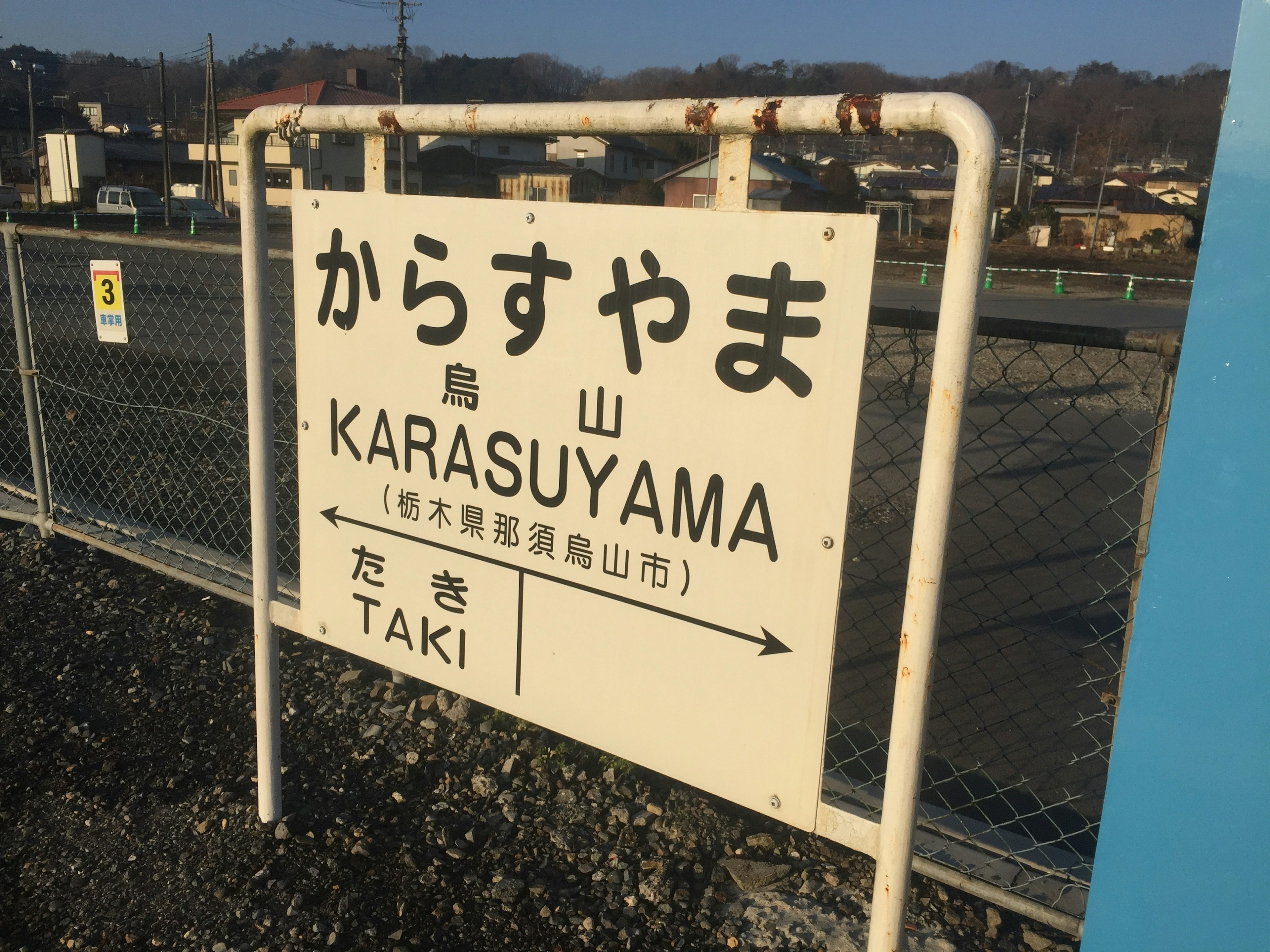 Schild der Station Karasuyama mit Richtungspfeilen