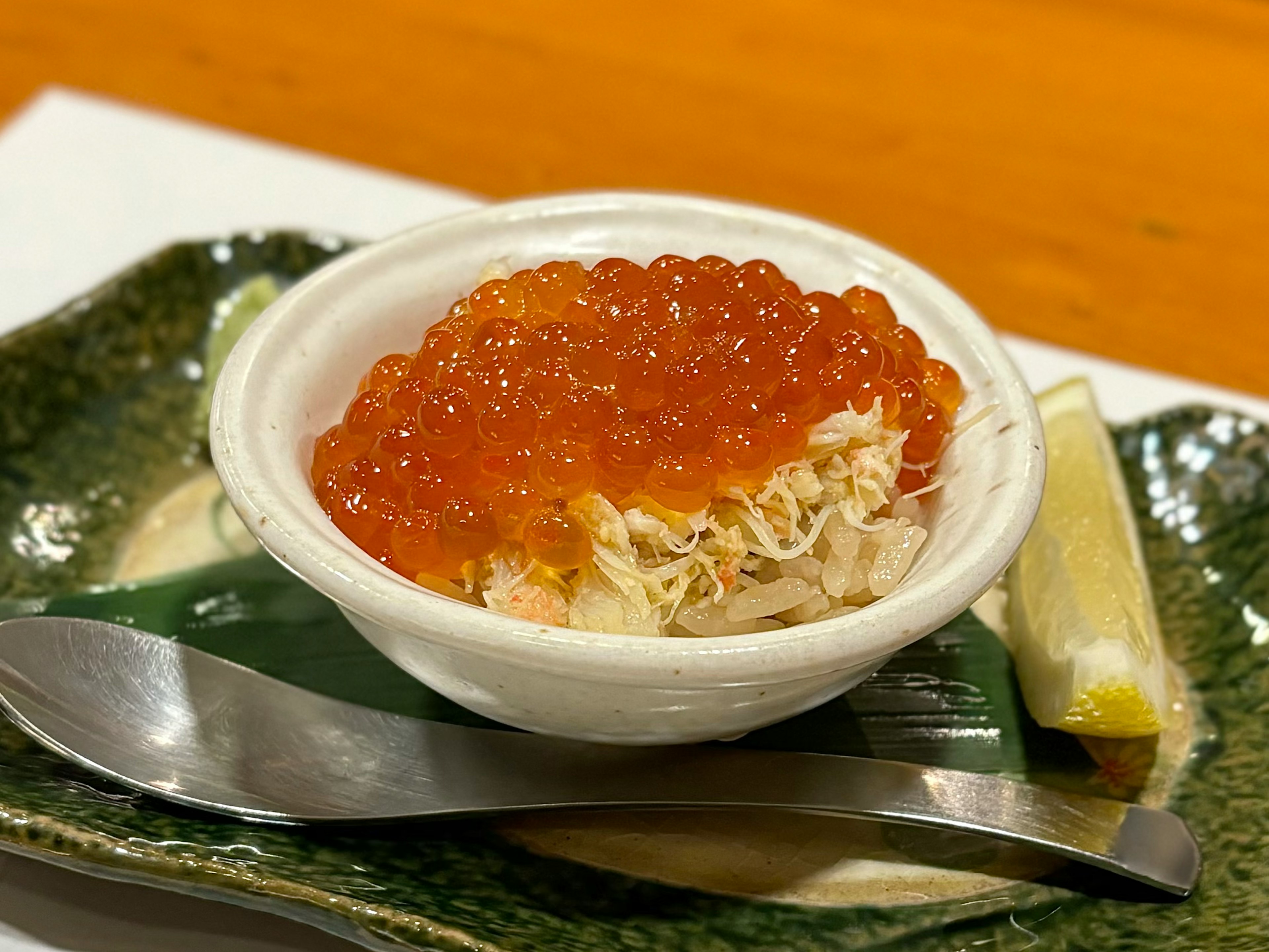 Plat avec de la chair de crabe surmontée d'œufs de saumon dans un bol