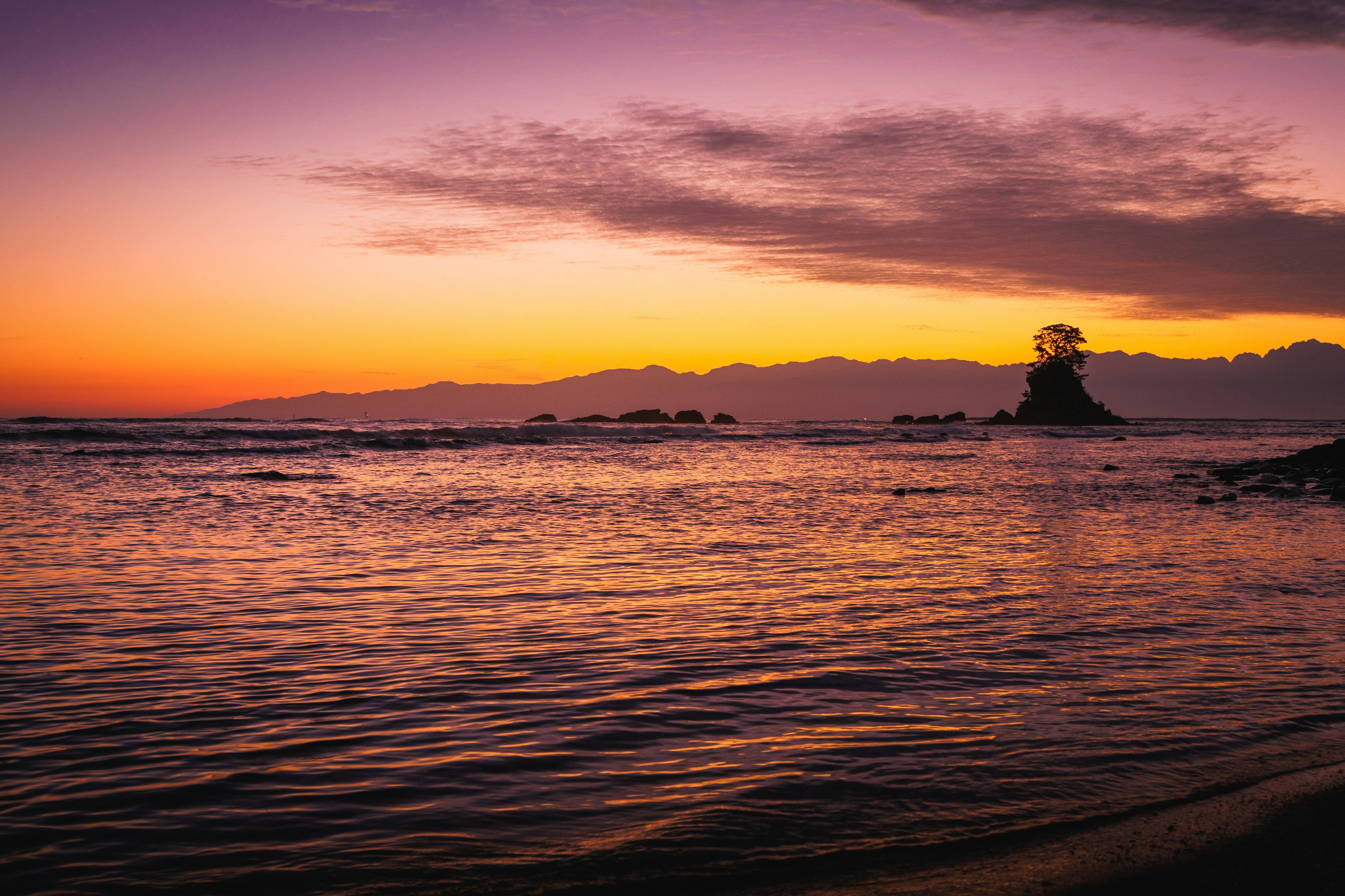 Splendido tramonto su un oceano calmo che riflette tonalità viola