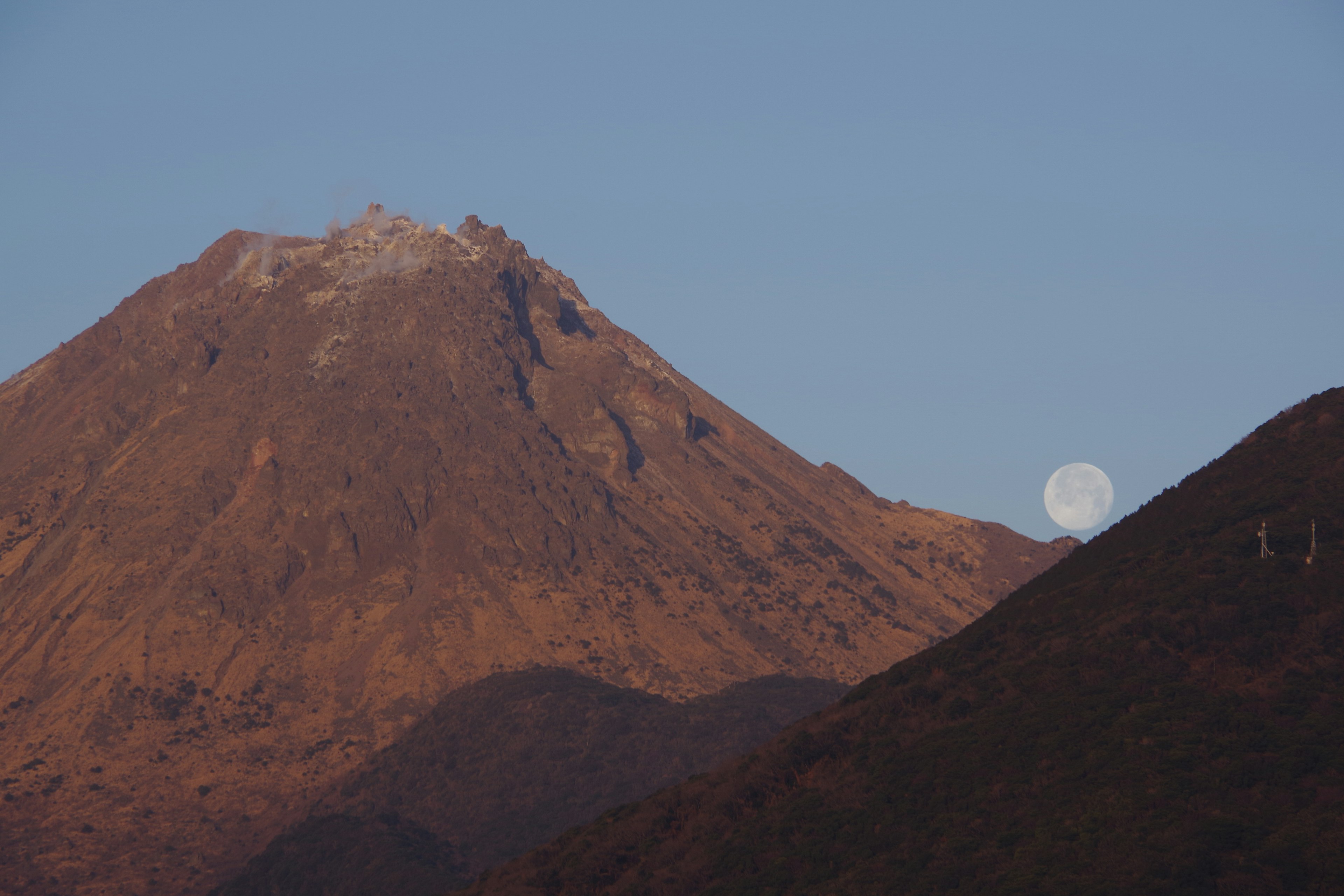 Vista panoramica di un vulcano con la luna sullo sfondo