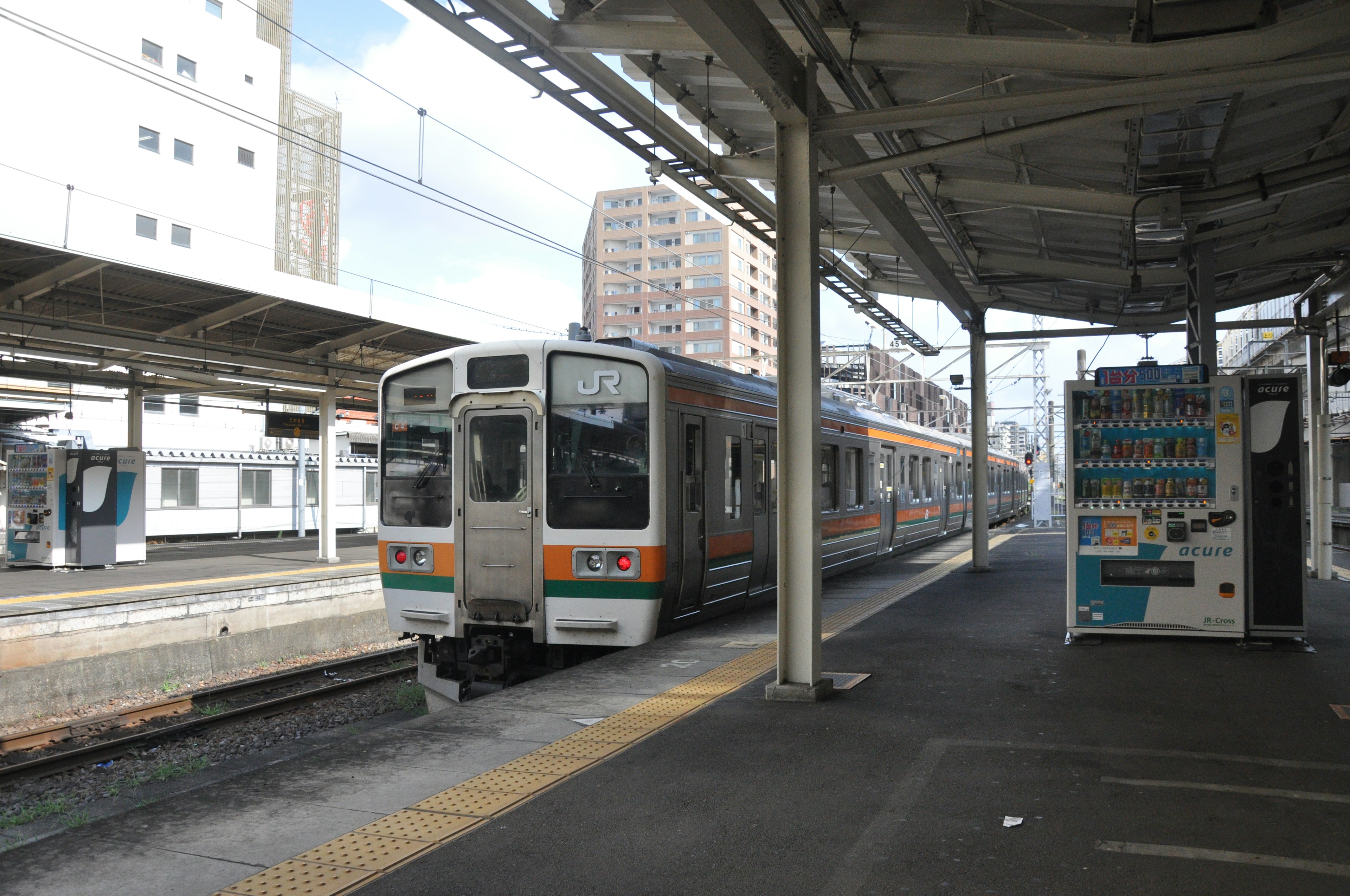 Treno fermo in una stazione con edifici circostanti