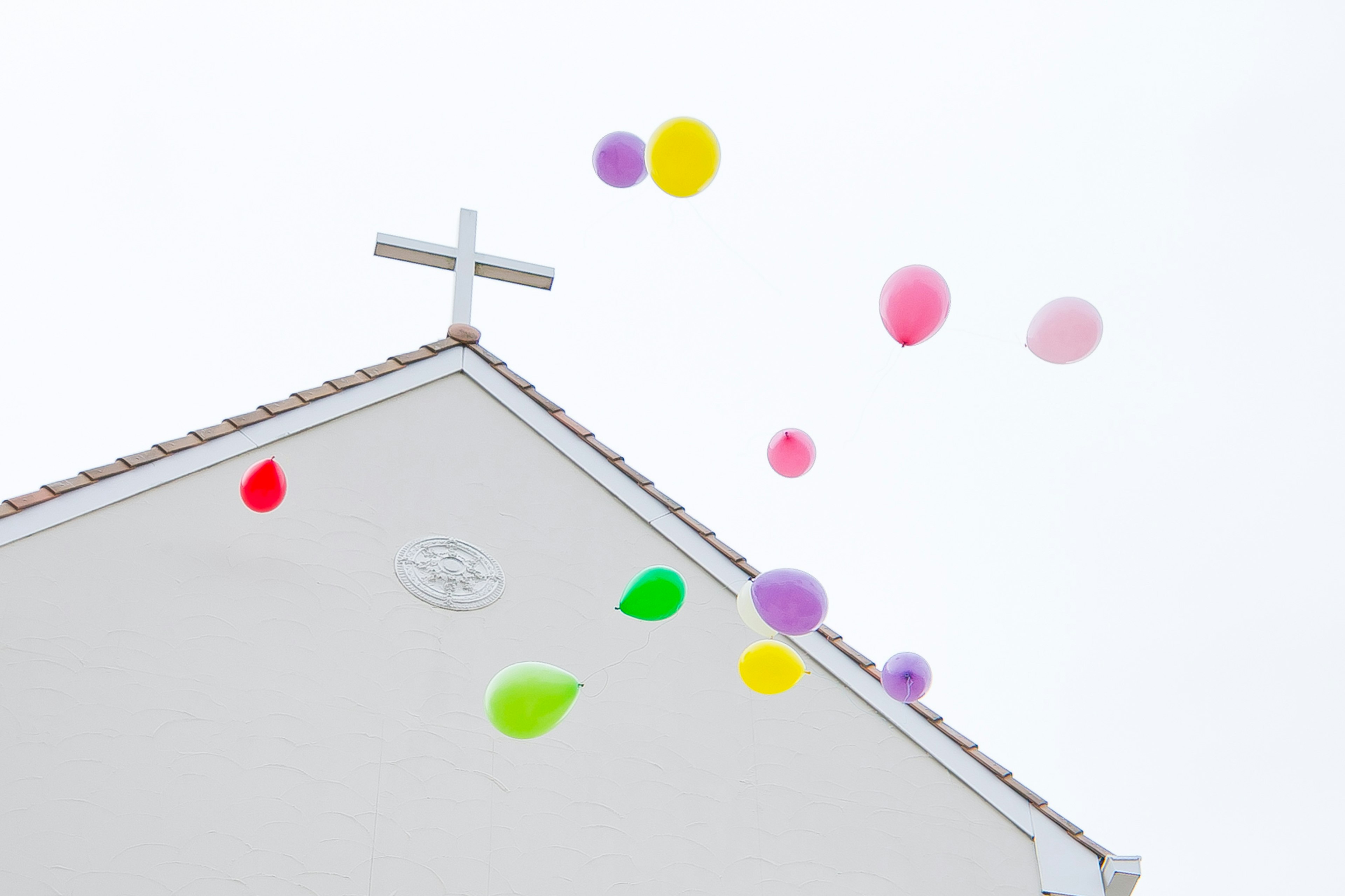 Globos coloridos flotando sobre el techo de una iglesia