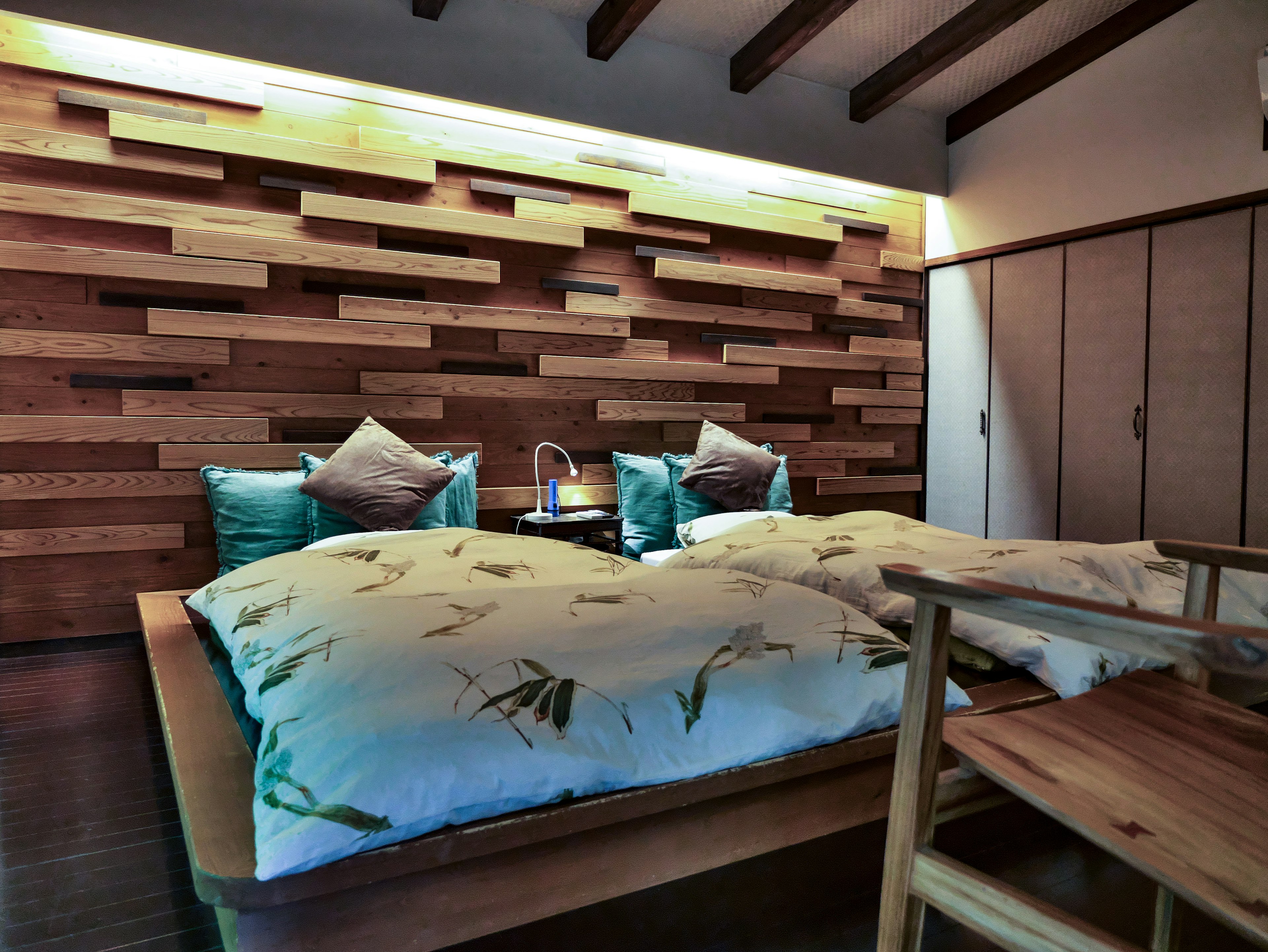 Cozy bedroom with wooden wall and comfortable bedding