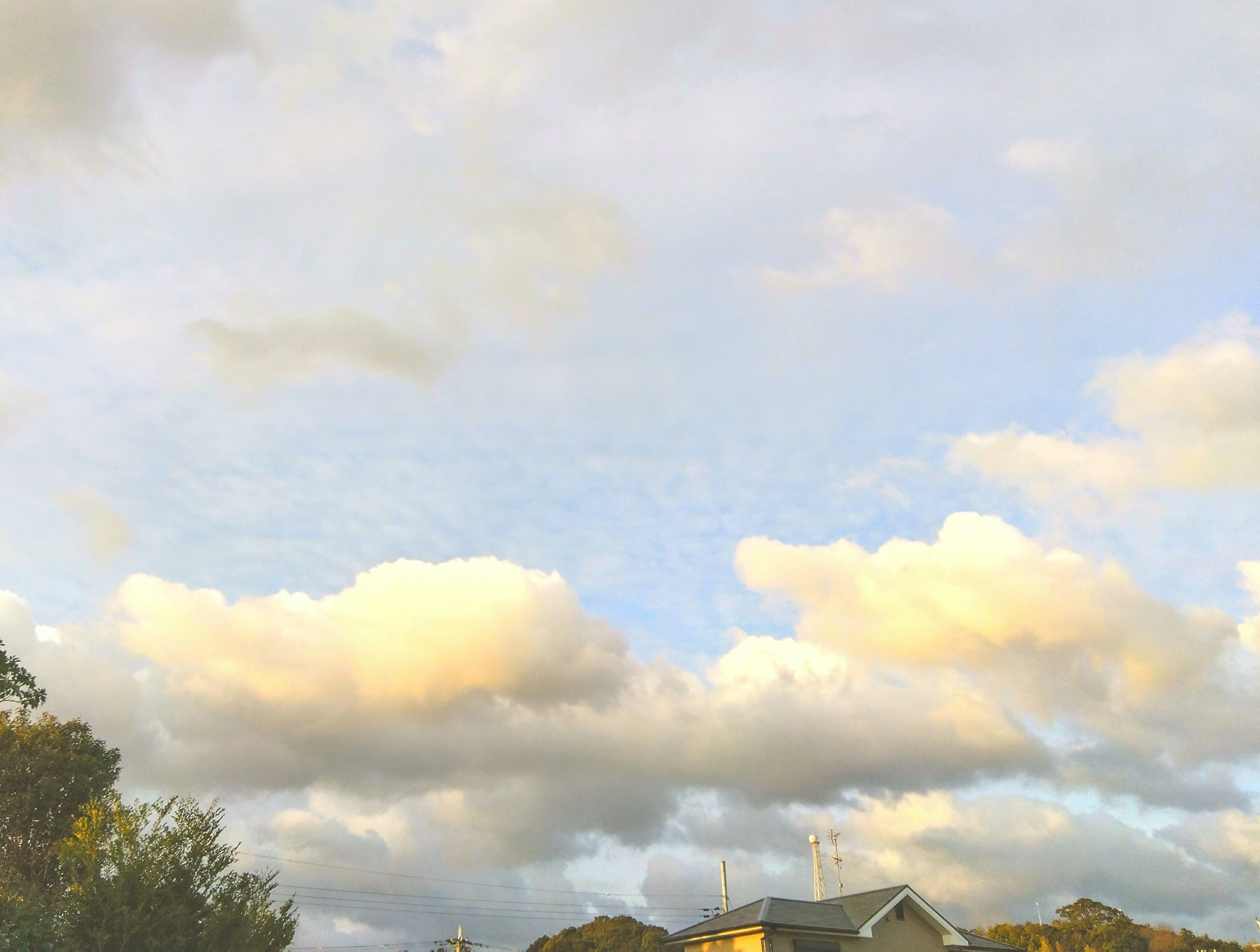 青空と雲が広がる風景に家が見える