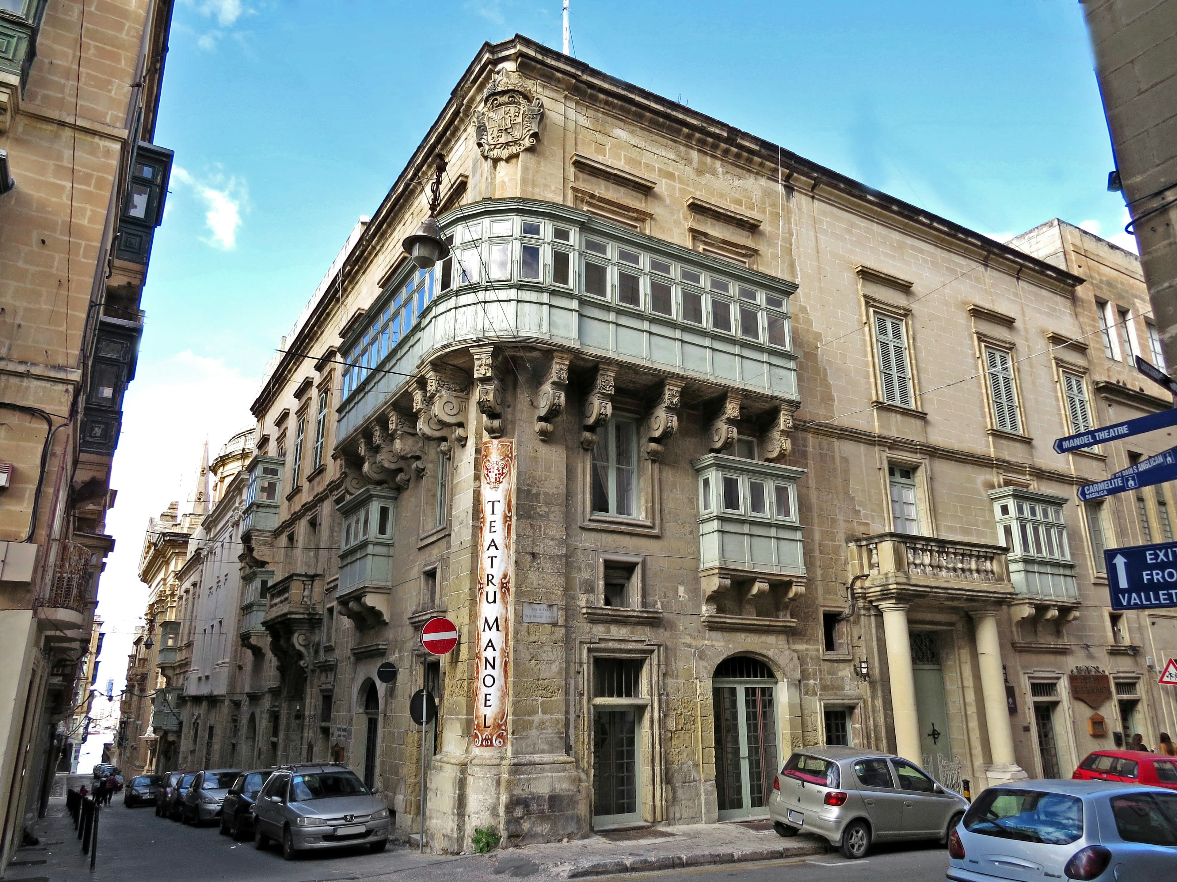 Edificio histórico con balcón ornamentado en una calle estrecha