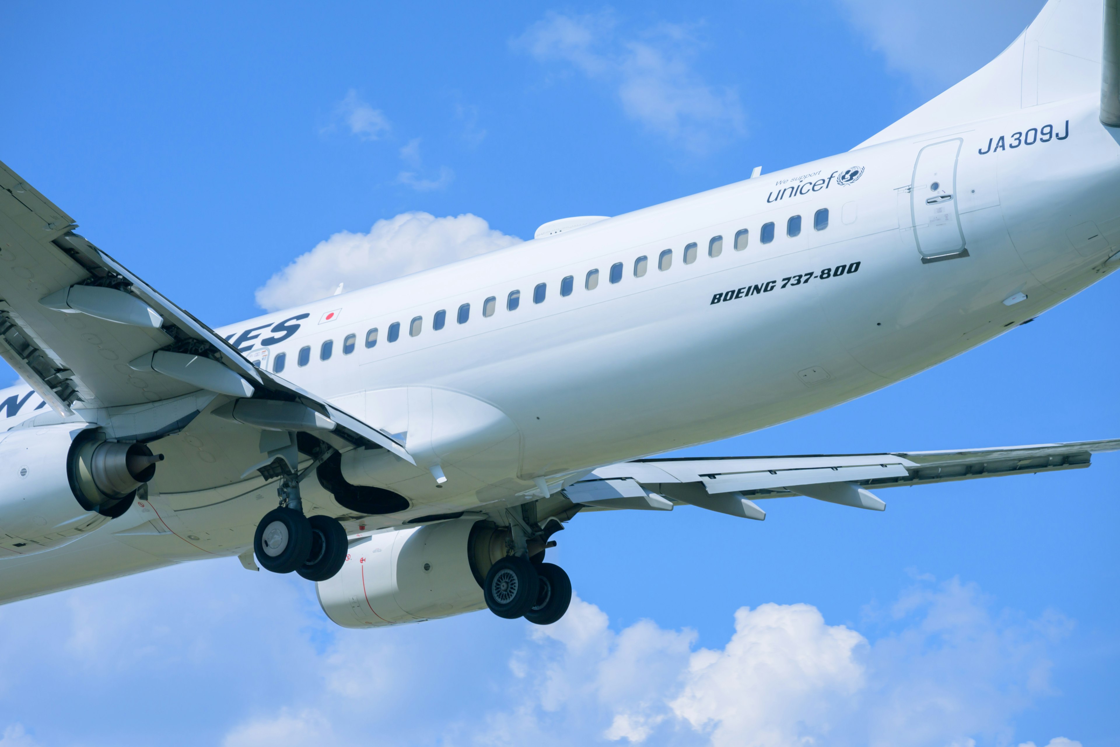 White passenger airplane approaching against a blue sky