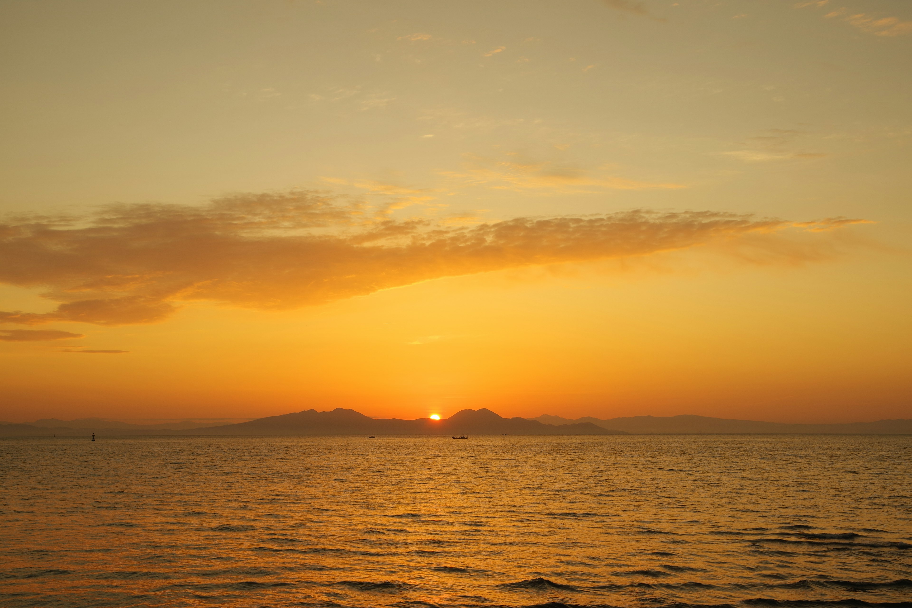 Atardecer sobre el océano con un cielo naranja